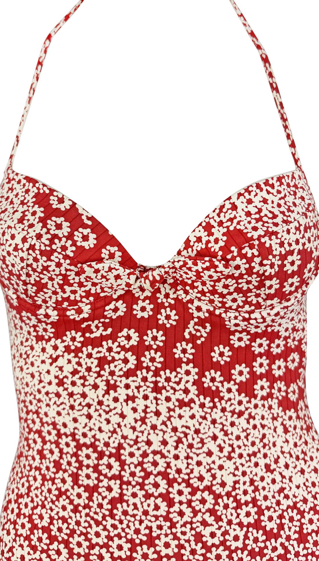 From Chanel’s Spring/Summer 2003 collection by Karl Lagerfeld, this red and white mini dress features a structured sweetheart neckline with delicate bust ruching and a halter strap that ties at the back for an adjustable fit. The diagonal floral