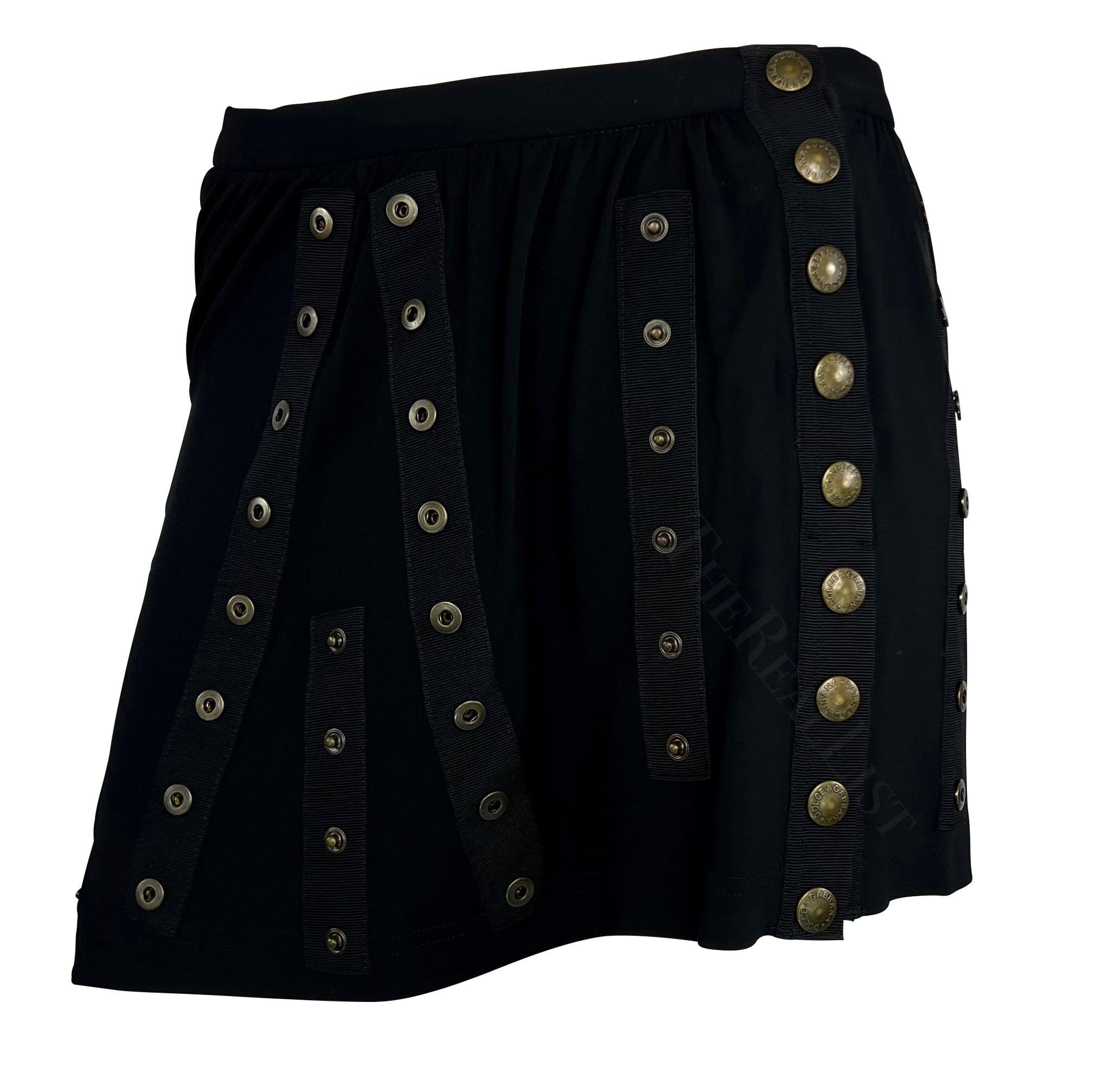 Presentinga fabulous black Dolce and Gabbana snap mini skirt. From the Spring/Summer 2003 ‘Sex and Love’ collection, this skirt is covered in many snaps that allow it to be fitted and worn to the wearer’s desire. Many looks in the following