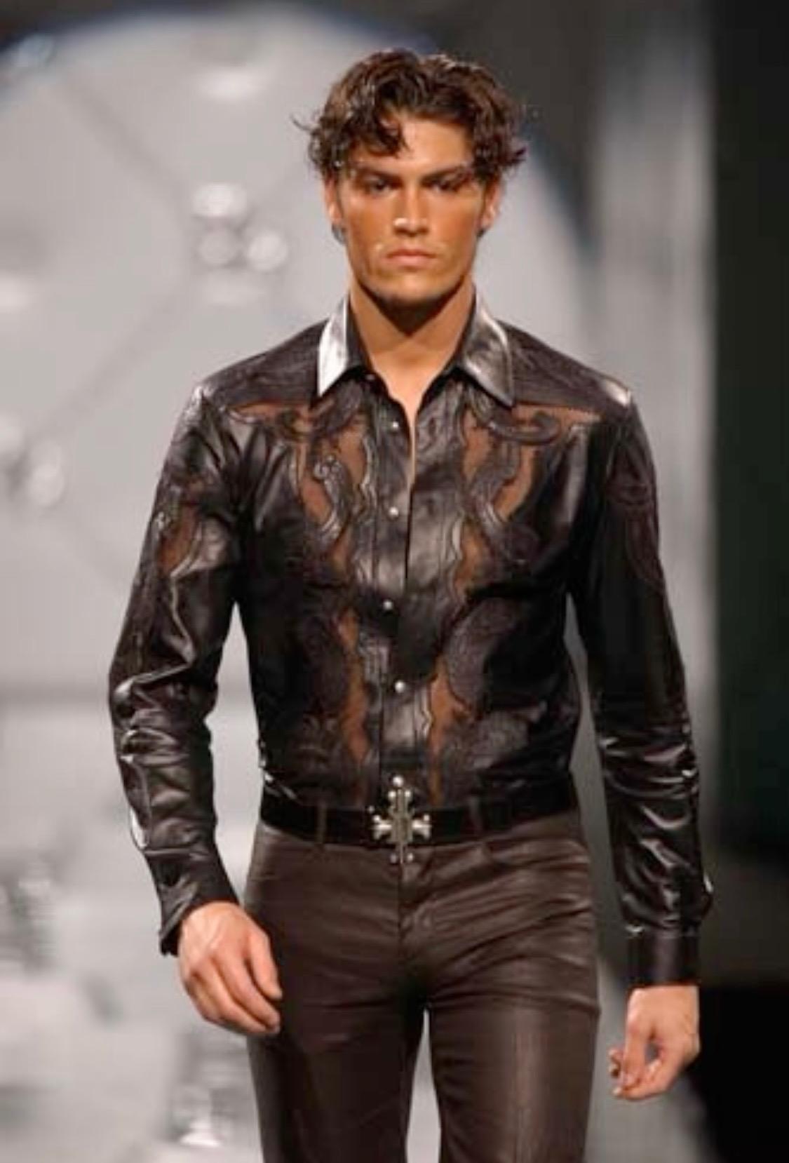 Presenting an embroidered cutout leather button-up shirt designed by Donatella for the Spring/Summer 2003 Gianni Versace Menswear runway. This rock-n-roll-inspired shirt features floral mesh embroidery and 'DV' monogram logo buttons down the center