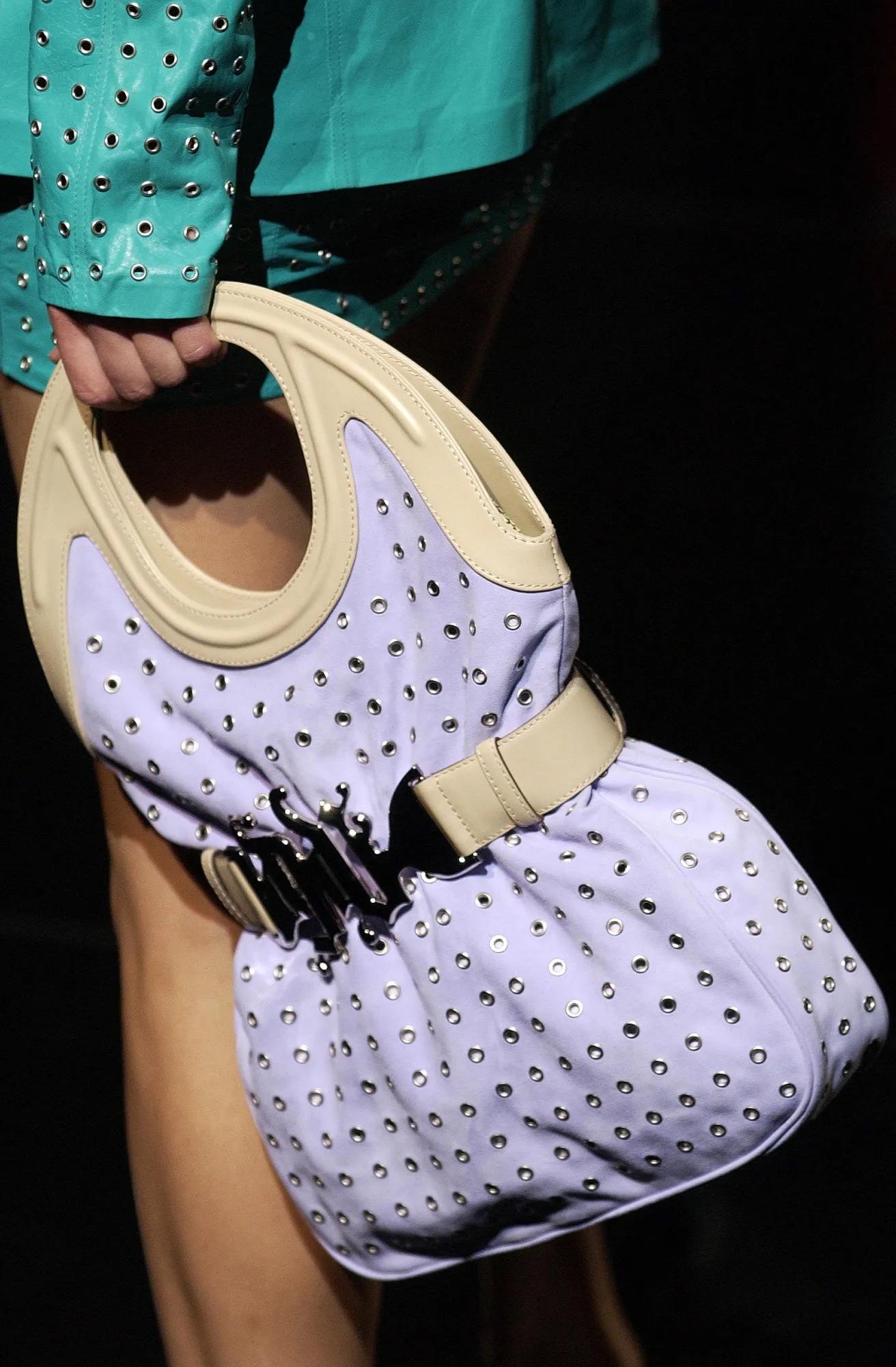 Donatella Versace designed this chic black woven bag for her Spring/Summer 2003 Gianni Versace collection. A version of this bag debuted on the season's runway. This all-black bag features a black woven body with black leather accents. This