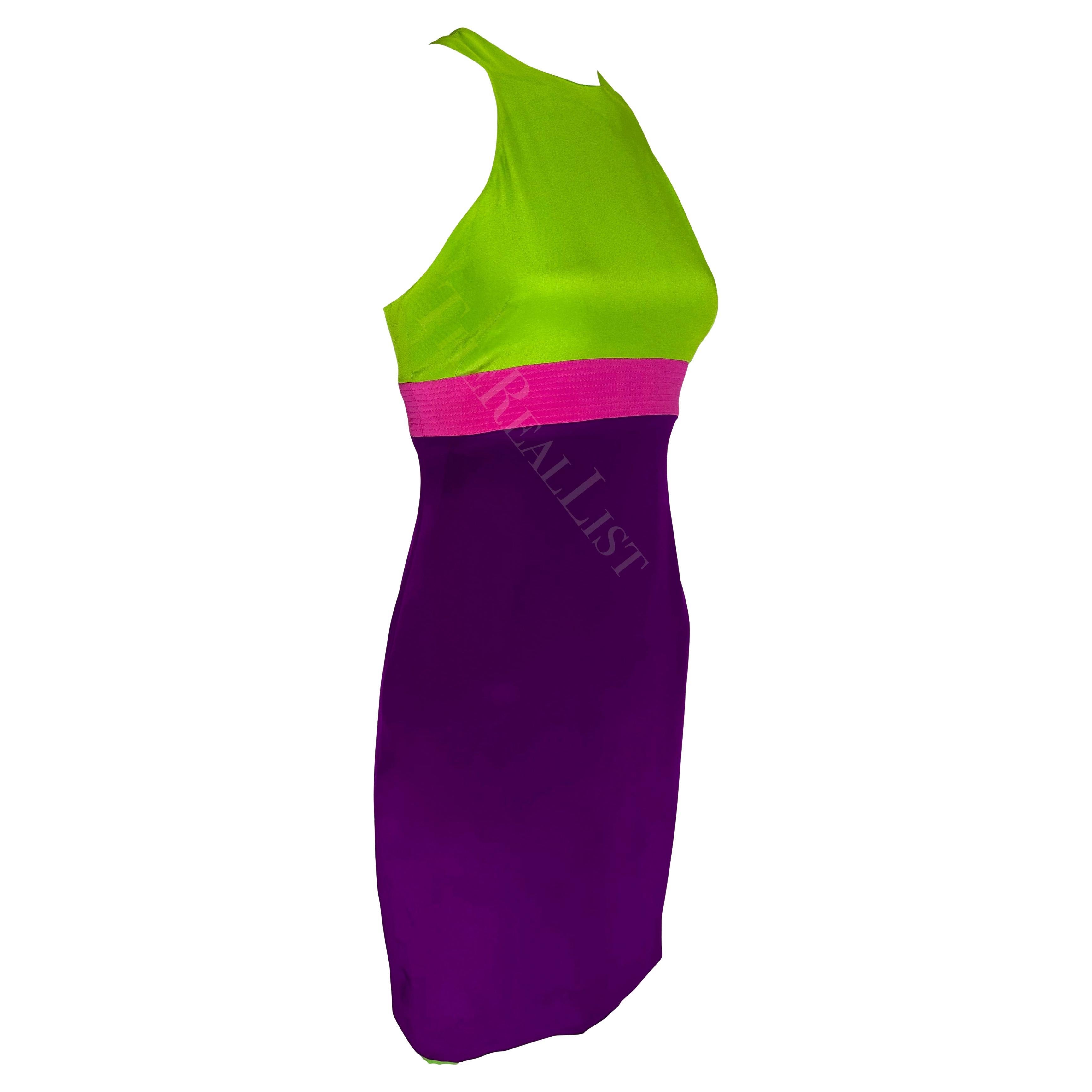 Présentation d'une mini robe violette et verte Gianni Versace, dessinée par Donatella Versace. Issue de la collection printemps/été 2003, cette robe color block hyper-girly présente un haut vert, une jupe violette et une bande rose vif sous le