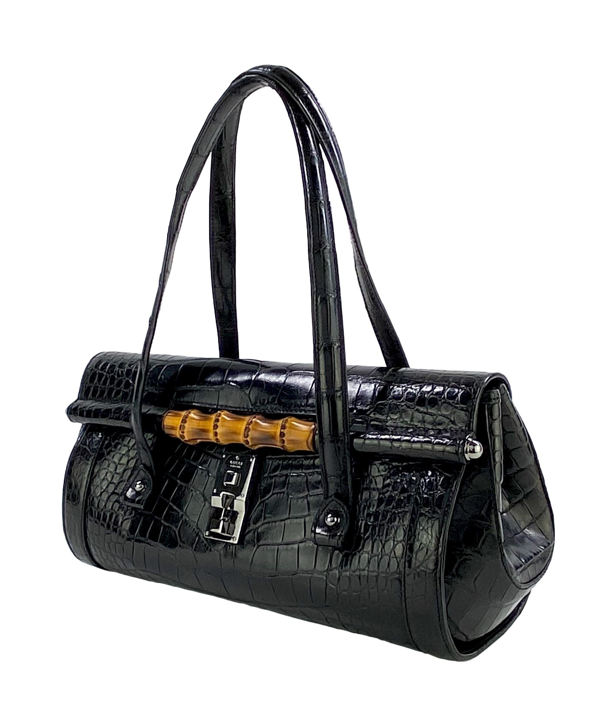 Presenting a gorgeous black crocodile skin Gucci bullet bag, designed by Tom Ford. This iconic Tom Ford design was taken to a whole new level when he constructed the bullet bag fully in shiny alligator skin. This gorgeous bag is from the