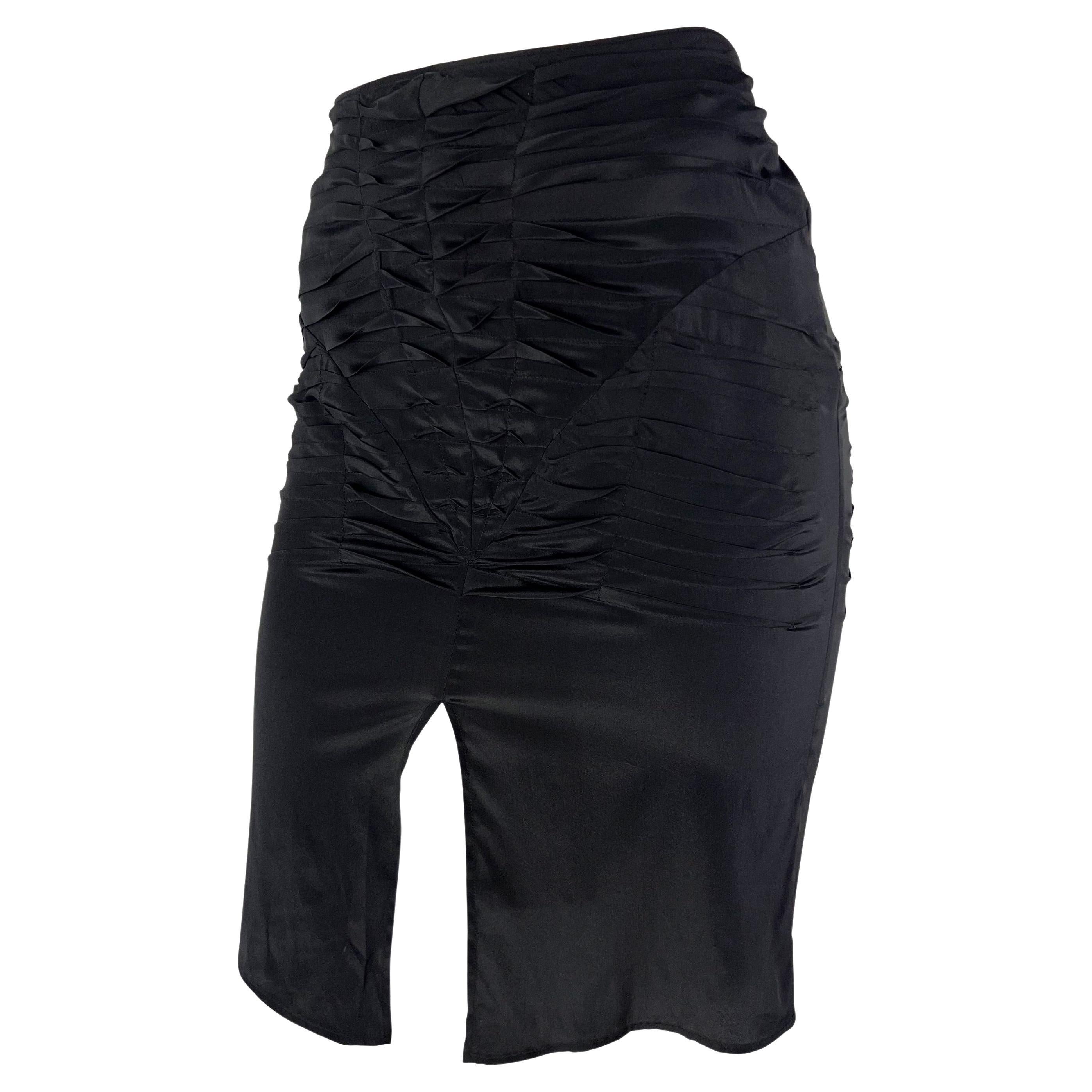 Cette jupe en soie noire de Gucci, conçue par Tom Ford, fait partie de la collection printemps/été 2003. La jupe présente des plis autour des hanches, ce qui crée une silhouette flatteuse en soulignant les courbes naturelles du corps. Il est