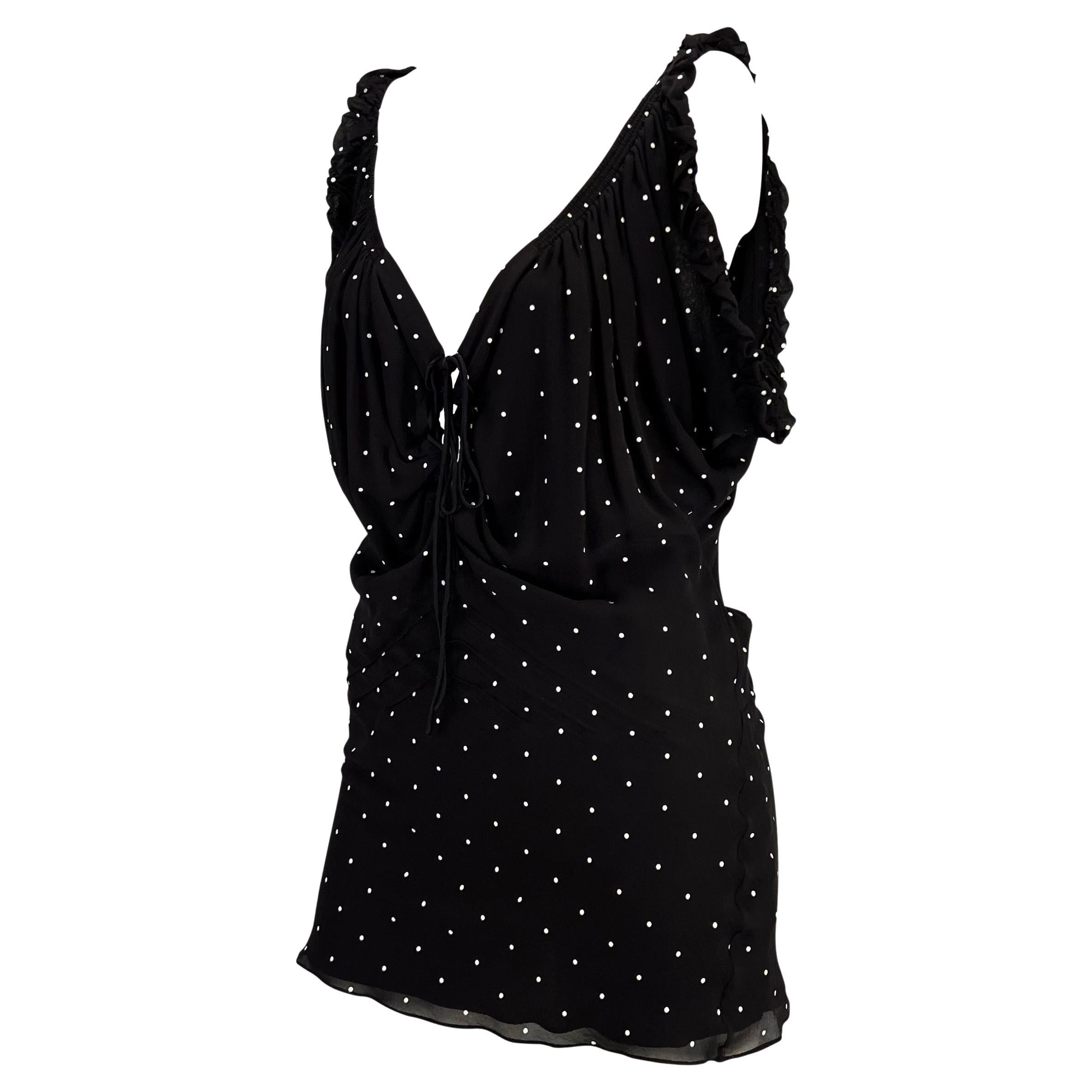 Presenting a sexy polka dot Gucci mini dress, designed by Tom Ford. From the Spring/Summer 2003 collection, this black dress with white dots features winged underarms, a v-neckline, and a low scooped back. Made complete with a small opening and tie