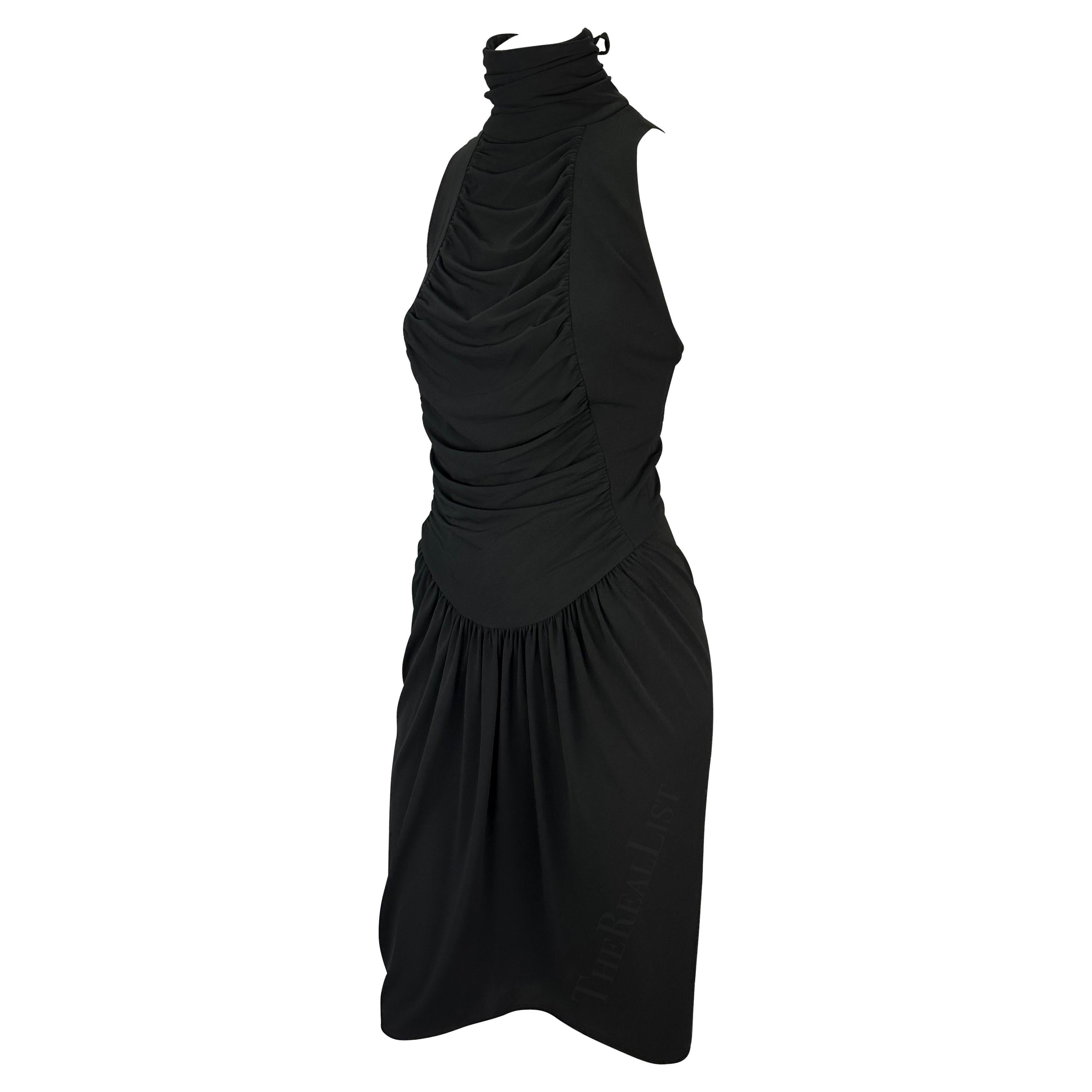 Présentation d'une robe midi noire chic à dos nu Karl Lagerfeld. Issue de sa collection de prêt-à-porter printemps/été 2003, cette robe a fait ses débuts sur le podium de la saison. Dotée d'un col simili, d'un drapé sur le devant et d'un dos exposé,