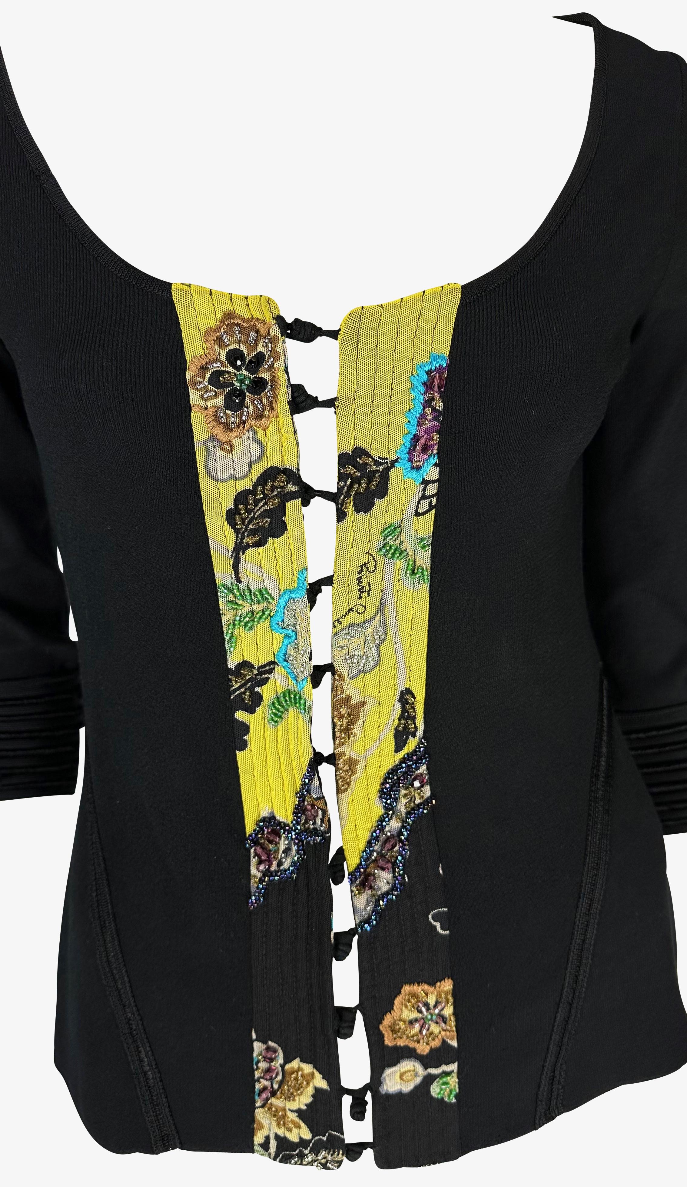 Présentation d'un magnifique pull en chinoiserie noir et jaune Roberto Cavalli. Issu de la collection Printemps/Eté 2003, ce fabuleux pull présente des manches mi-longues, des fermetures à grenouillère, un imprimé chinoiserie jaune perlé qui tapisse