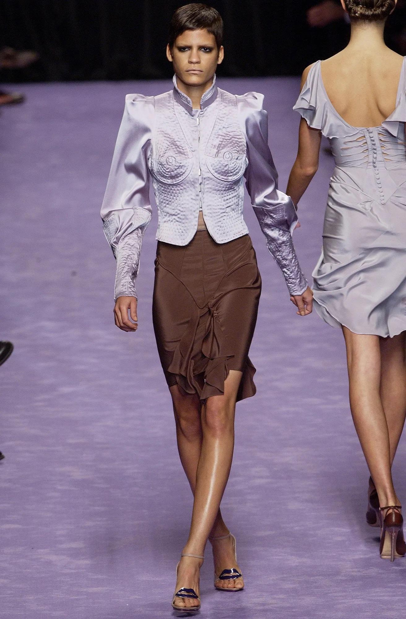 From Tom Ford’s Spring/Summer 2003 collection for Yves Saint Laurent, this black silk pencil skirt features sculptural seam detailing and a cascading front ruffle that opens into a slit. Cut to flatter the waist and hips, the design appeared on the