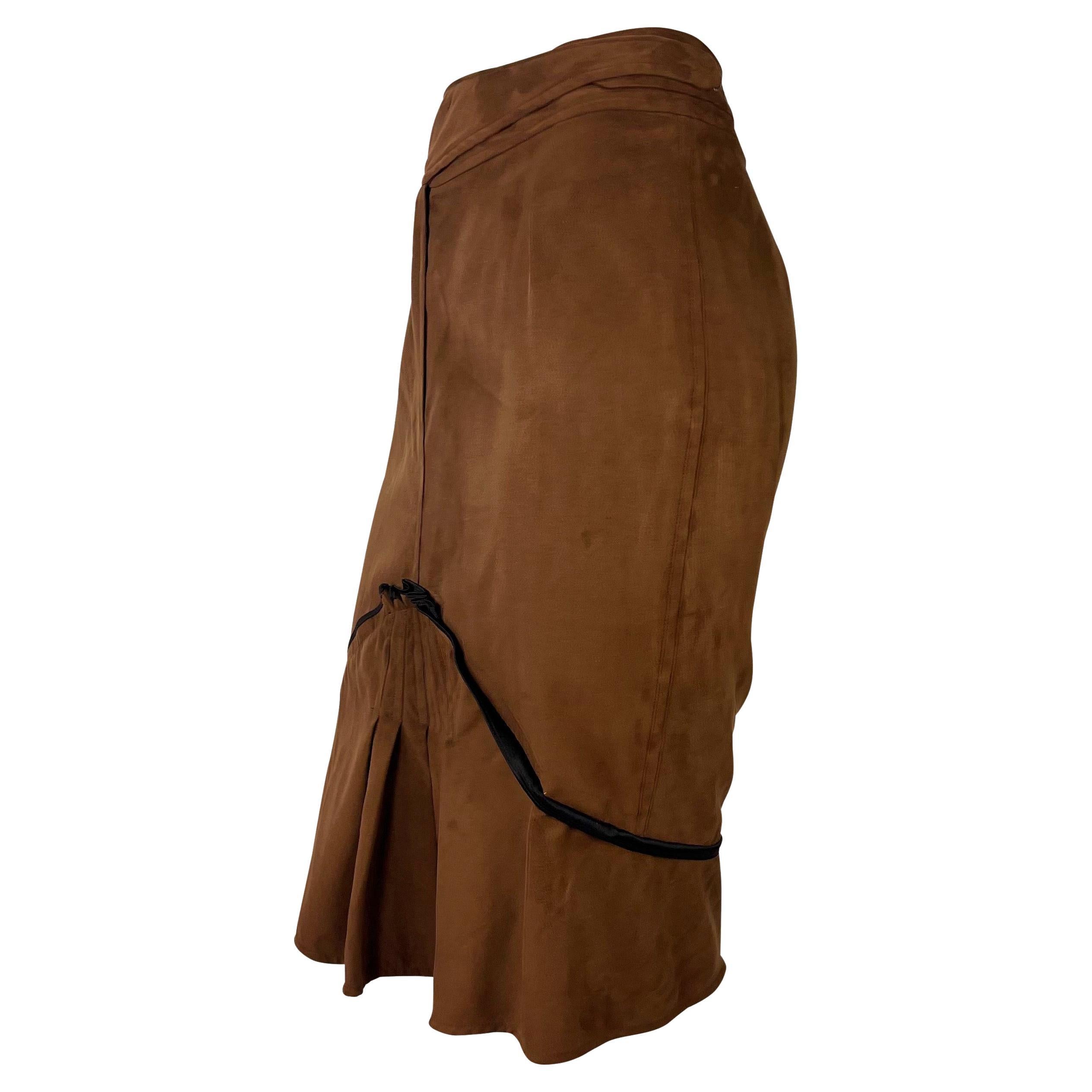 TheRealList presents: a cross-over brown vegan suede skirt designed by Tom Ford for Yves Saint Laurent Rive Gauche's Spring/Summer 2003 collection. Many of the looks on the season's runway featured the same brown microsuede fabric. Eyelets and hooks