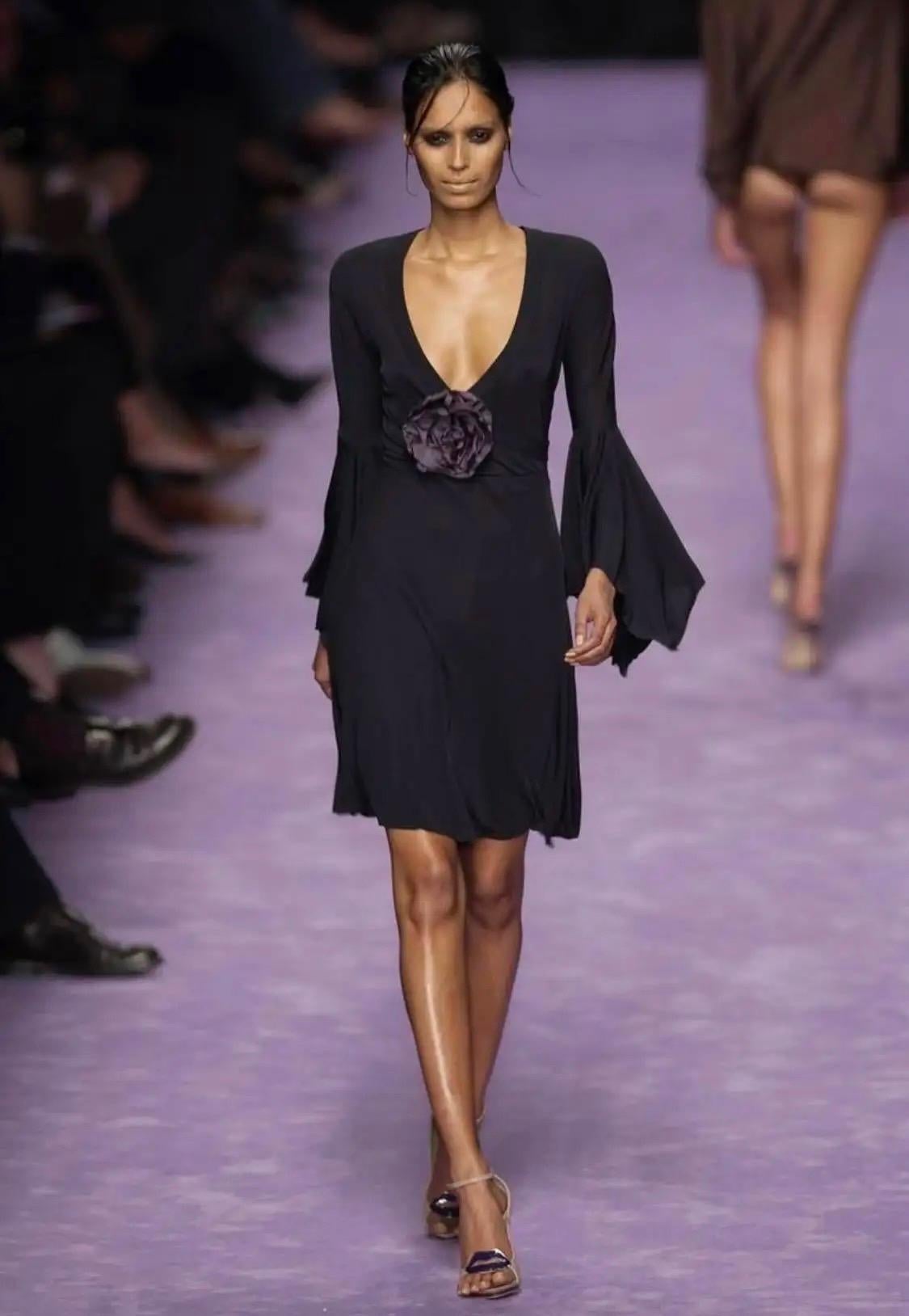 Presenting a lavender stretch top designed by Tom Ford for Yves Saint Laurent Rive Gauche's Spring/Summer 2003 collection. The bell sleeves and floral brooch elements were heavily featured on the season's runway, including a black dress version of