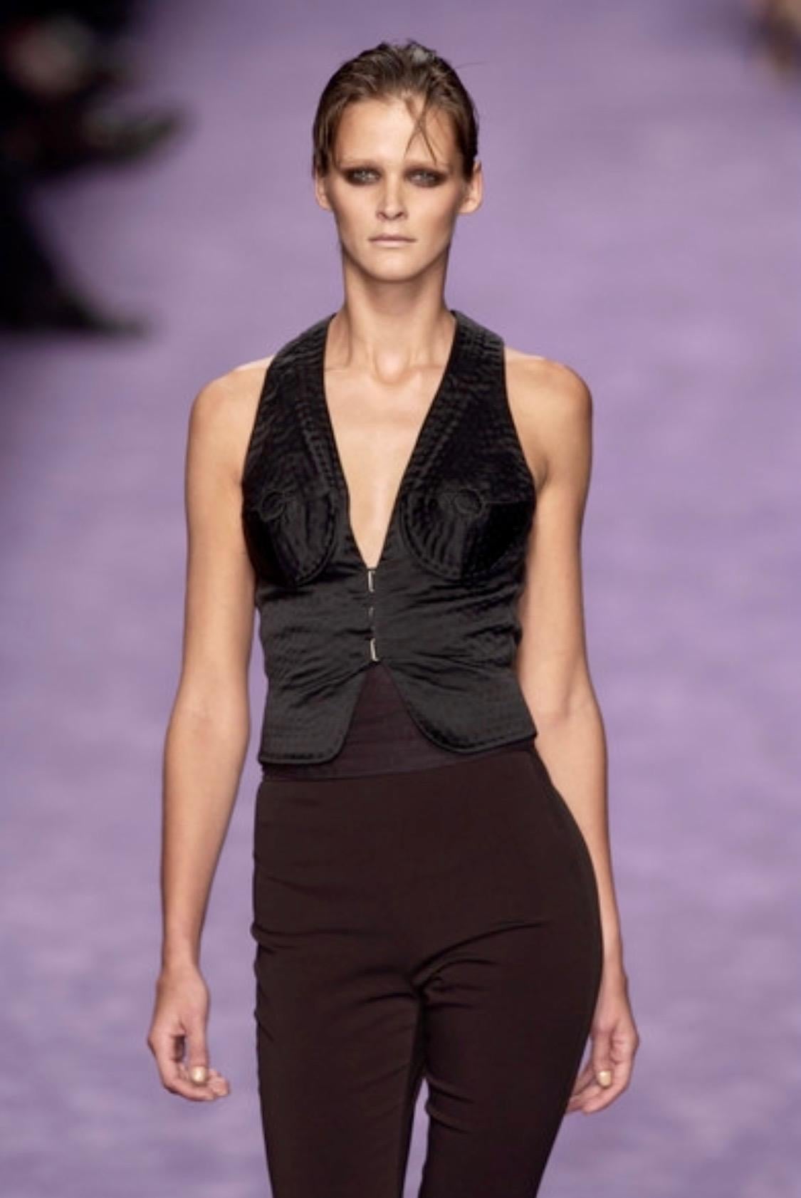 TheRealList presents: a black nude illusion Yves Saint Laurent Rive Gauche vest/top, designed by Tom Ford. This eye-catching vest debuted on look number 33 on Carmen Kass in the Spring/Summer 2003 runway presentation. The patterned stitching