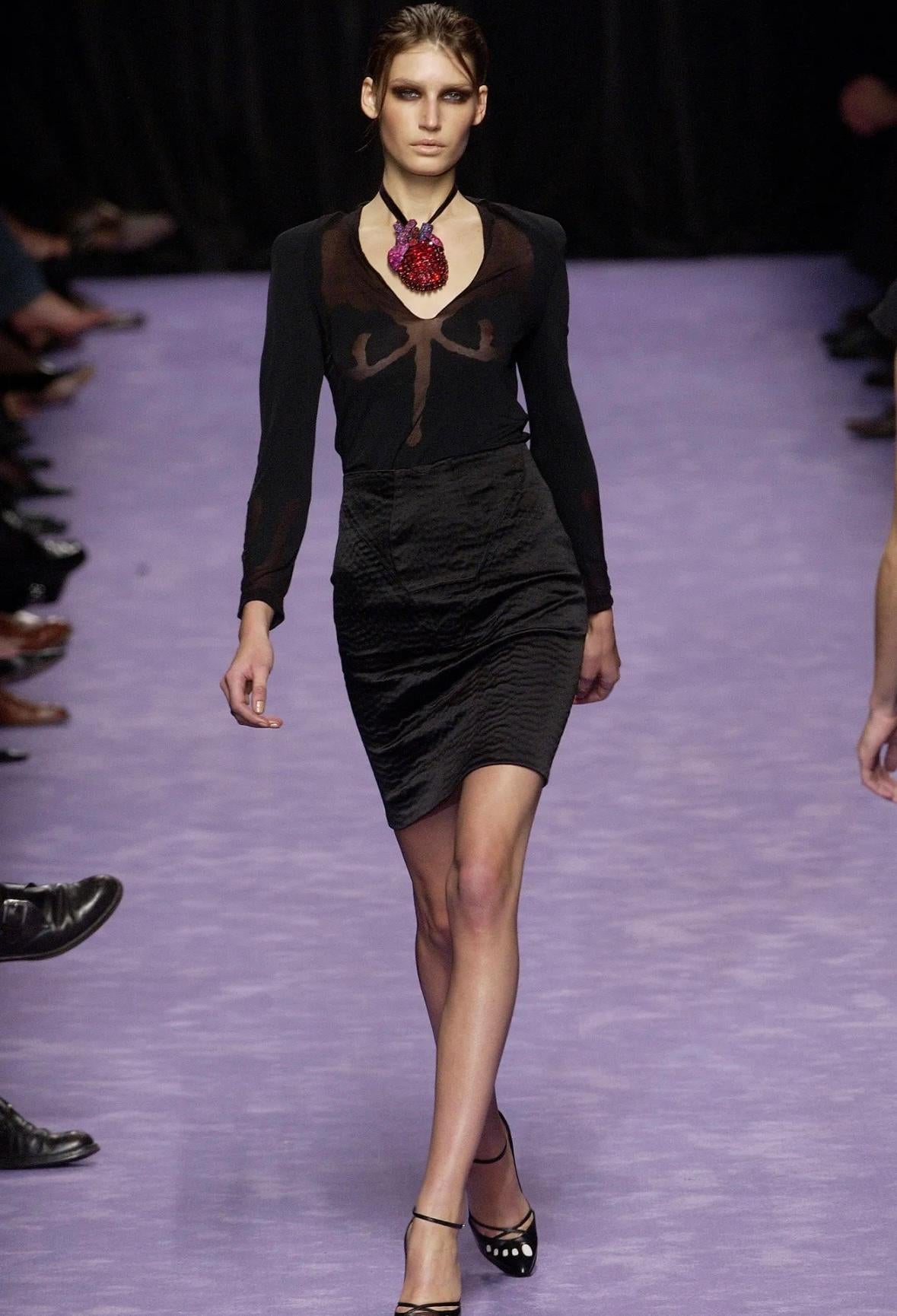 De la colección Primavera/Verano 2003 de Yves Saint Laurent con Tom Ford, este top negro de manga larga presenta paneles transparentes que forman un motivo anatómico abstracto por delante y por detrás. El top debutó en la pasarela de la temporada