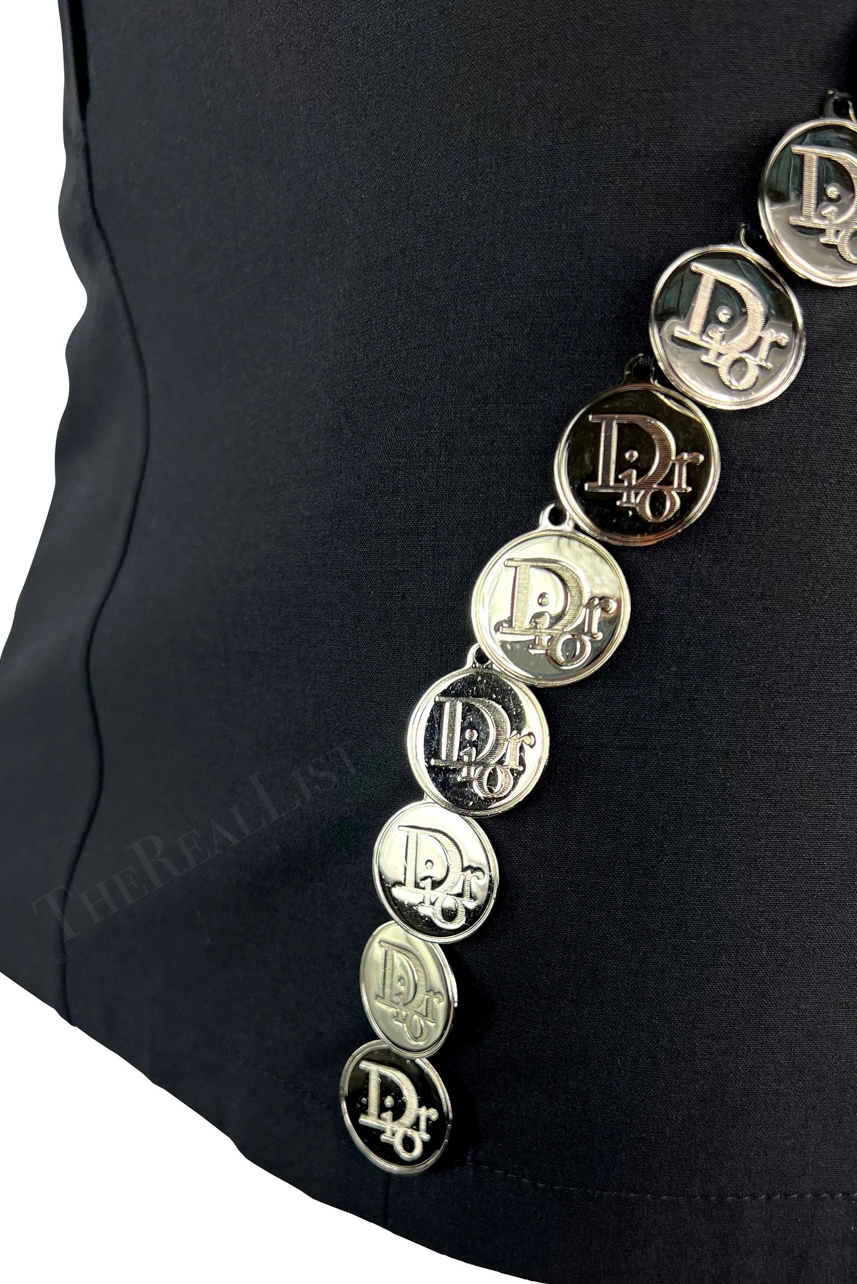 Presenting a fabulous black Christian Dior mini skirt, designed by John Galliano. From the Spring/Summer 2004 collection, this chic black skirt is elevated with silver-tone 'Dior' logo medallions that run down either side.

Size - 38FR/6US
Waistband