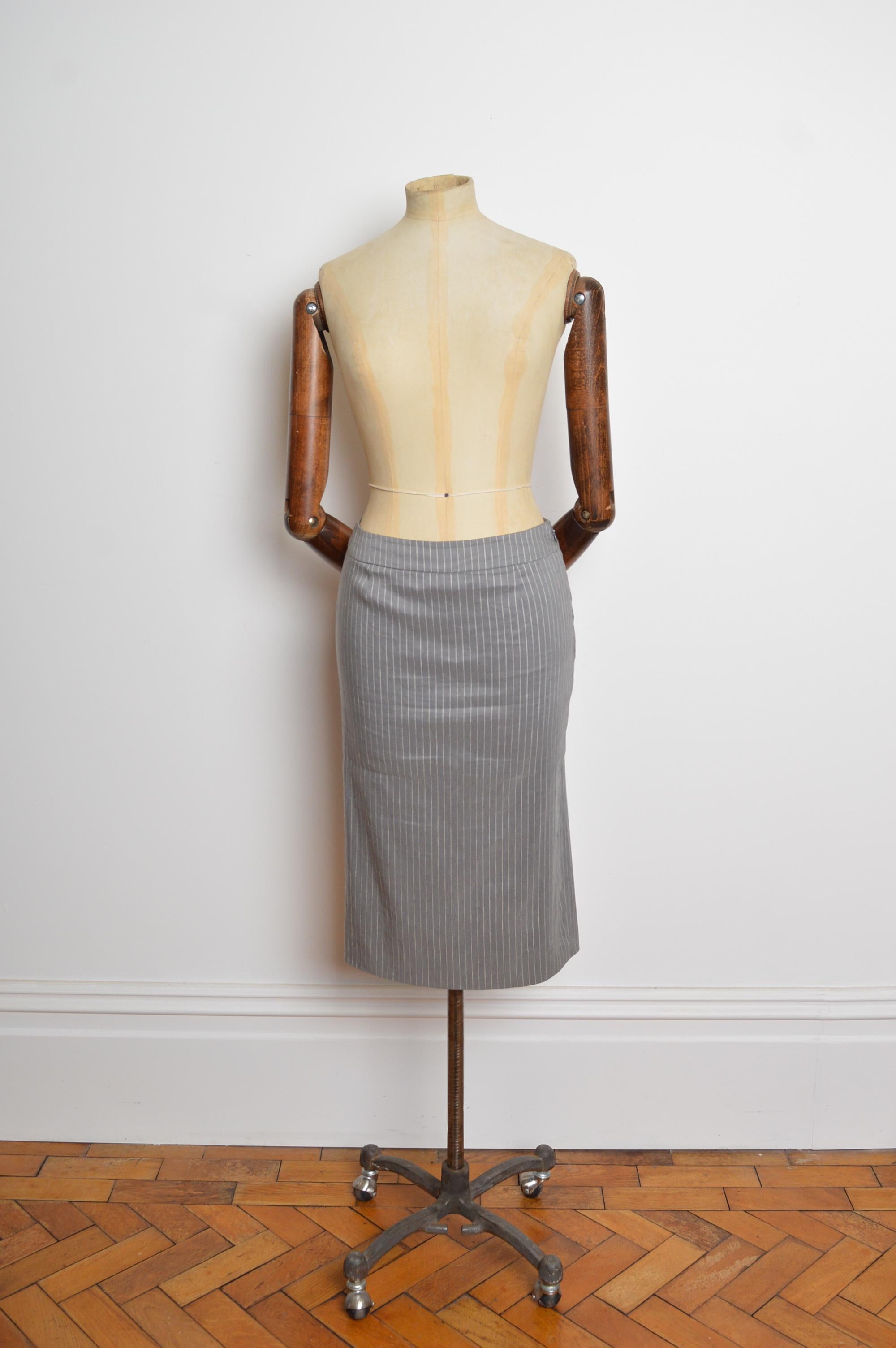 Un impeccabile abito grigio su misura primavera/estate 2004 di John Galliano for Christian Dior. Questo abito sartoriale a righe è caratterizzato da una silhouette sottile, chiusura a un bottone, tasche in vita e gonna a matita sartoriale con