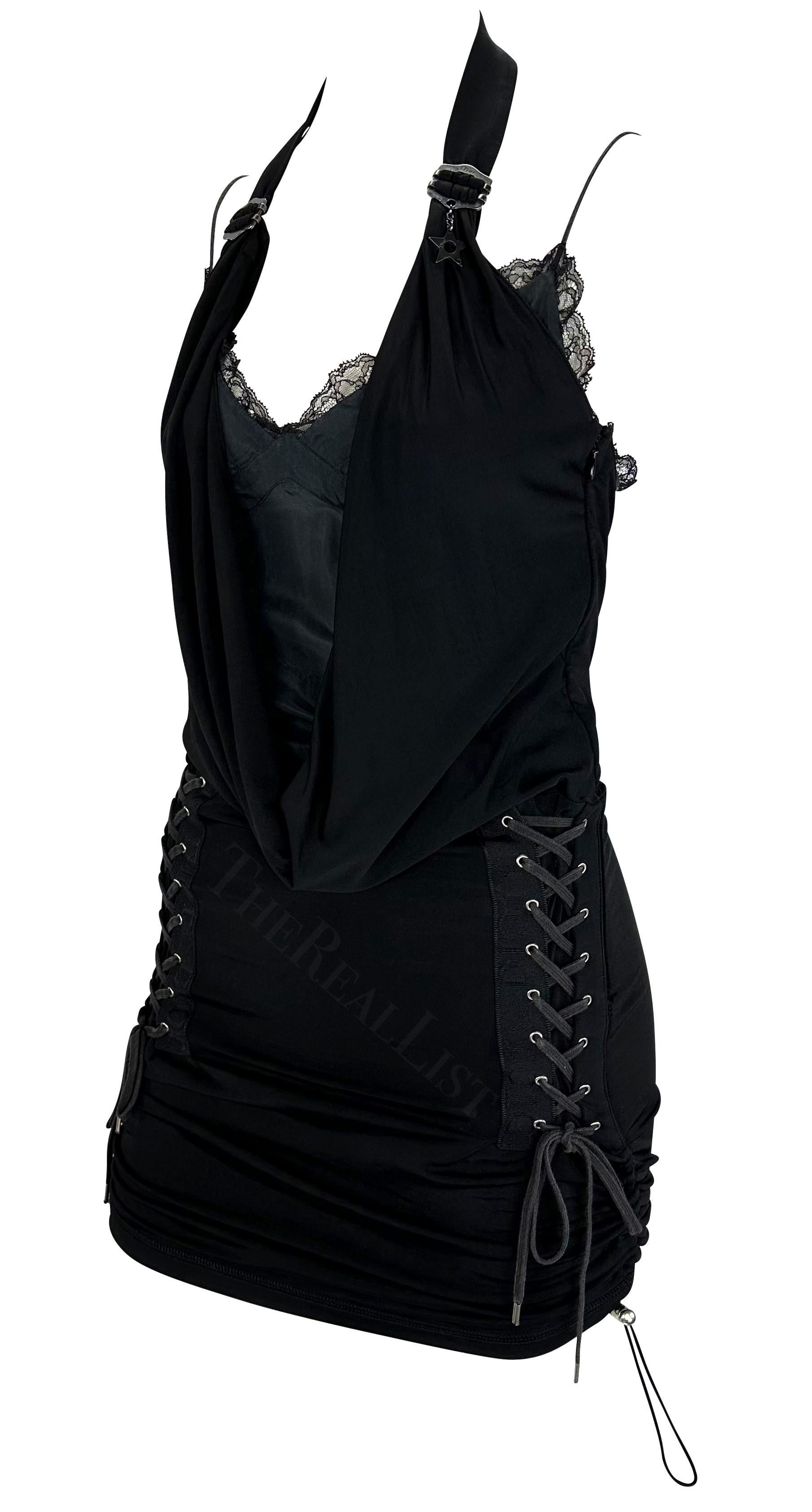 Présentation d'une fabuleuse mini robe noire Christian Dior, dessinée par John Galliano. Issue de la Collection S&Up 2004, cette robe sexy est dotée d'un dos nu qui se drape dans un col bénitier, d'accents de dentelle de chaque côté de la jupe et
