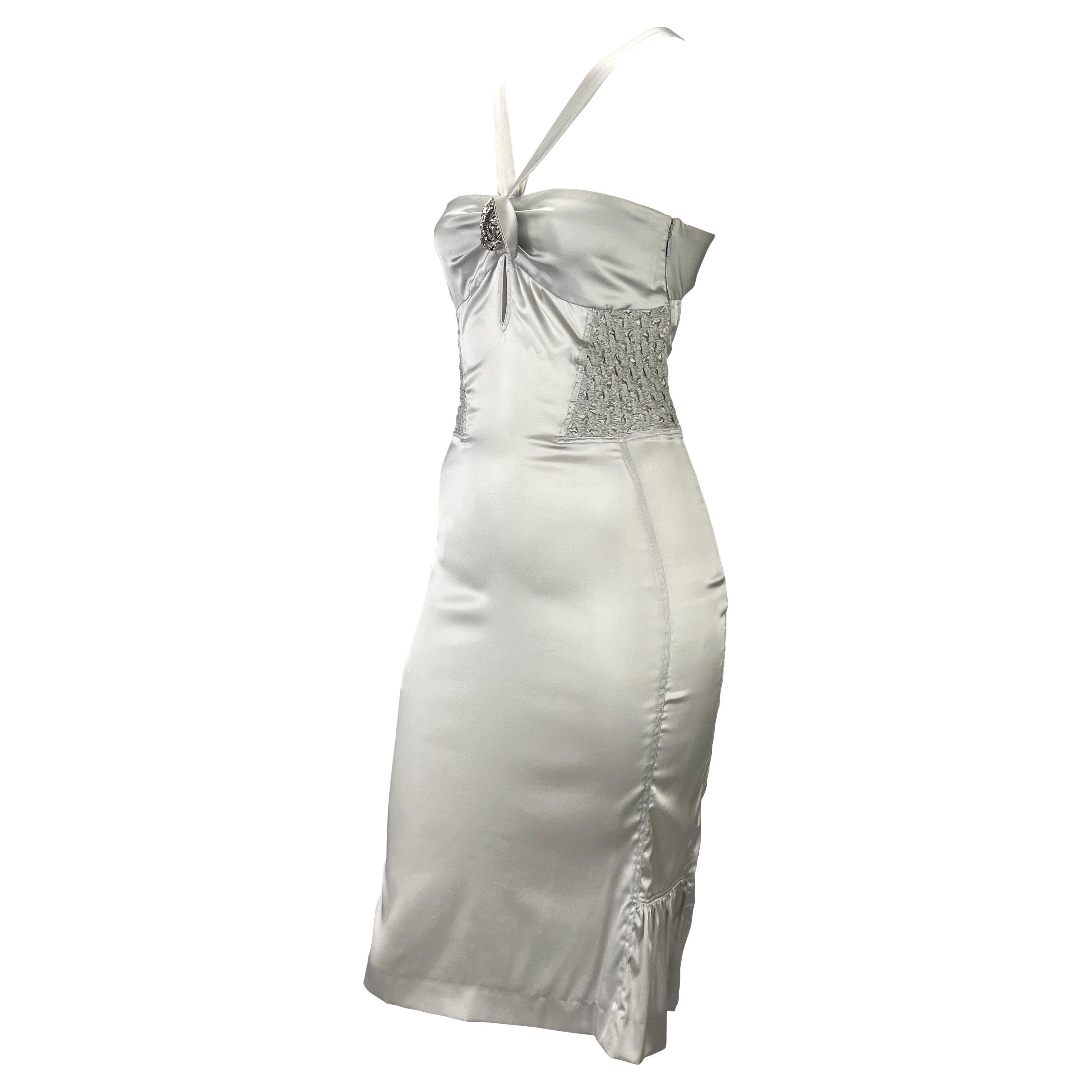 Presenting a beautiful silver silk ruched Gucci dress, designed by Tom Ford. From the Spring/Summer 2004 collection, this form-fitting dress features a Grecian-like neckline, keyhole cutout below the bust, and an exposed back. Ruched details add