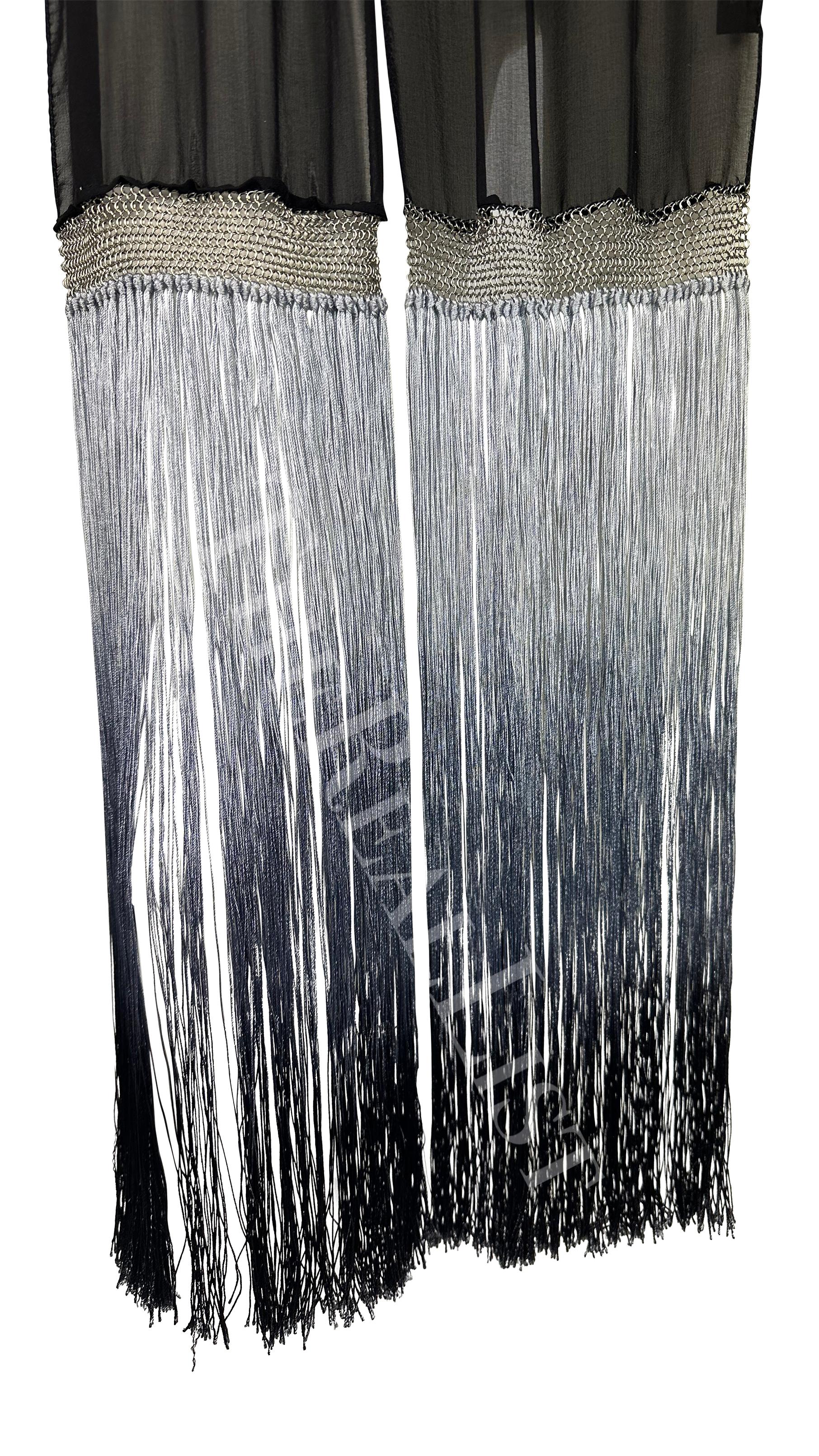 Presenting a black sheer fringe Gucci scarf, designed by Tom Ford. From the Spring/Summer 2004 collection, this chic scarf is made complete with a chain mail accent and ombre fringe.

Approximate measurements:
Length: 70