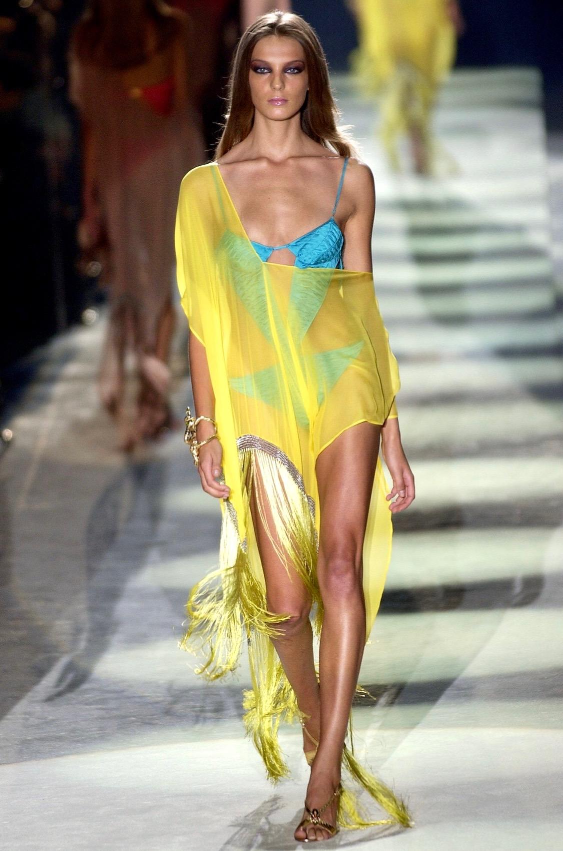 Presenting a bright yellow sheer Gucci cover-up, designed by Tom Ford. From the Spring/Summer 2004 collection this kaftan appeared on the runway as part of look number 24 on Daria Werbowy. Constructed primarily of a sheer canary yellow silk, this