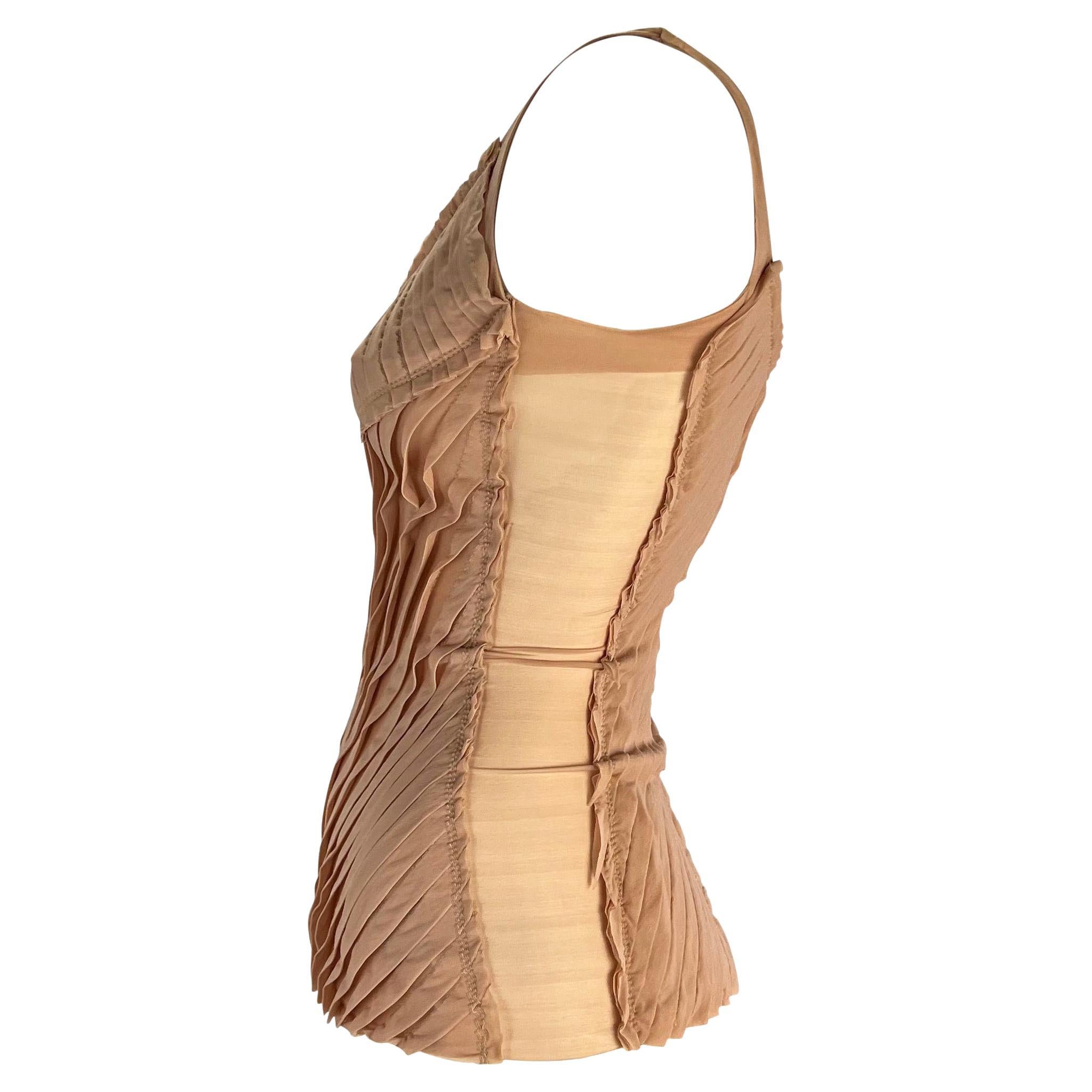 TheRealList presents: a blush ribbon Gucci tank top, designed by Tom Ford. From the Spring/Summer 2004 collection, this tank top features a scoop neckline, a semi exposed back, and mesh panels on the side. Not your average tank top, this shirt is