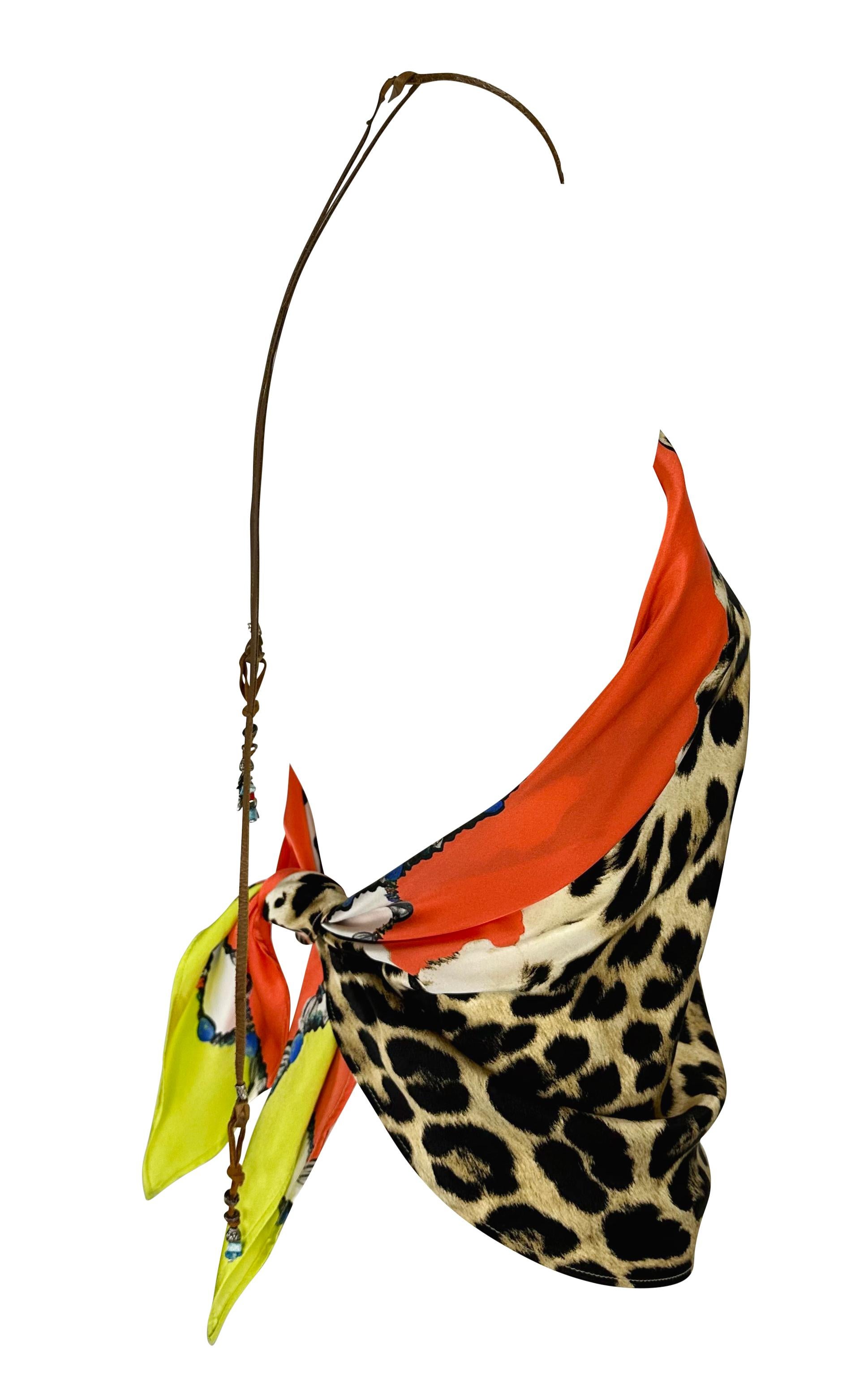 This chic jaguar printed Roberto Cavalli orange scarf top, from the Spring/Summer 2004 collection, is crafted entirely from silk. It ties at the back and features a leather halter strap with metal and turquoise beading at the ends.

Approximate