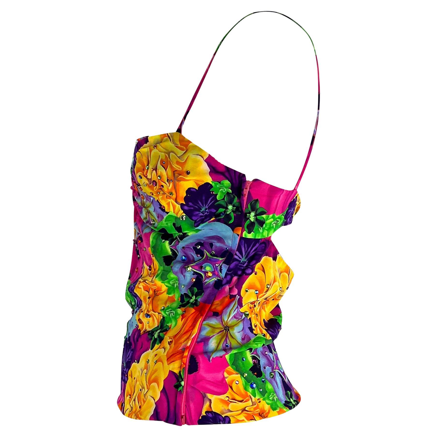 Presenting a bright floral Versace tank top, designed by Donatella Versace. From the Spring/Summer 2004 collection, this vibrant top is covered in a floral print with rhinestones throughout. The top features spaghetti straps, a semi-sweetheart neck