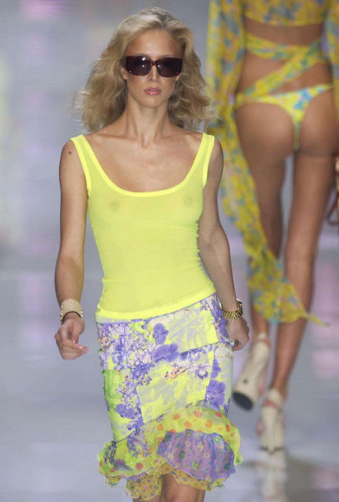 Presenting a neon green floral toile Versace skirt set, designed by Donatella Versace. From the Spring/Summer 2004 collection, this pattern first debuted on the season's runway on look 20 modeled by Raquel Zimmermann. The wrap top from this ruffly