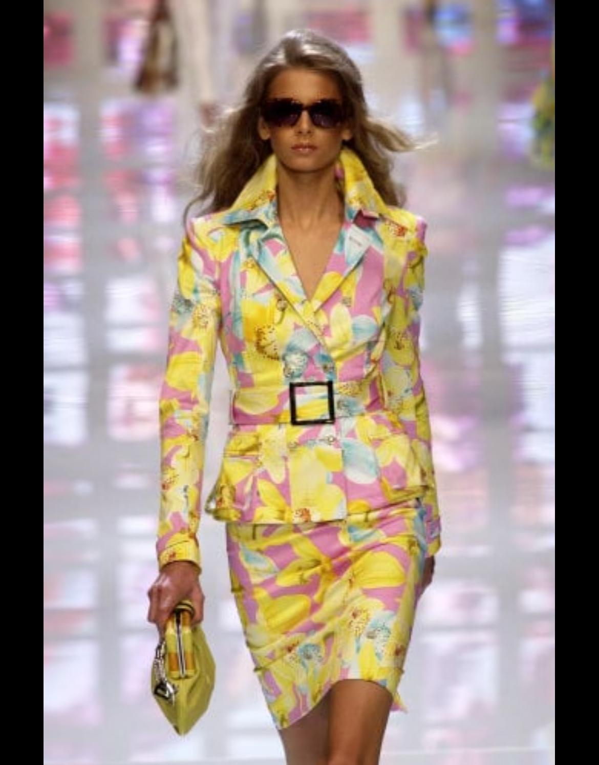Ti presentiamo un vibrante tailleur con gonna giallo floreale di Versace, disegnato da Donatella Versace. Dalla collezione Primavera/Estate 2004, questo set ha debuttato in passerella come look 7, modellato da Hana Soukupova. Una fusione di