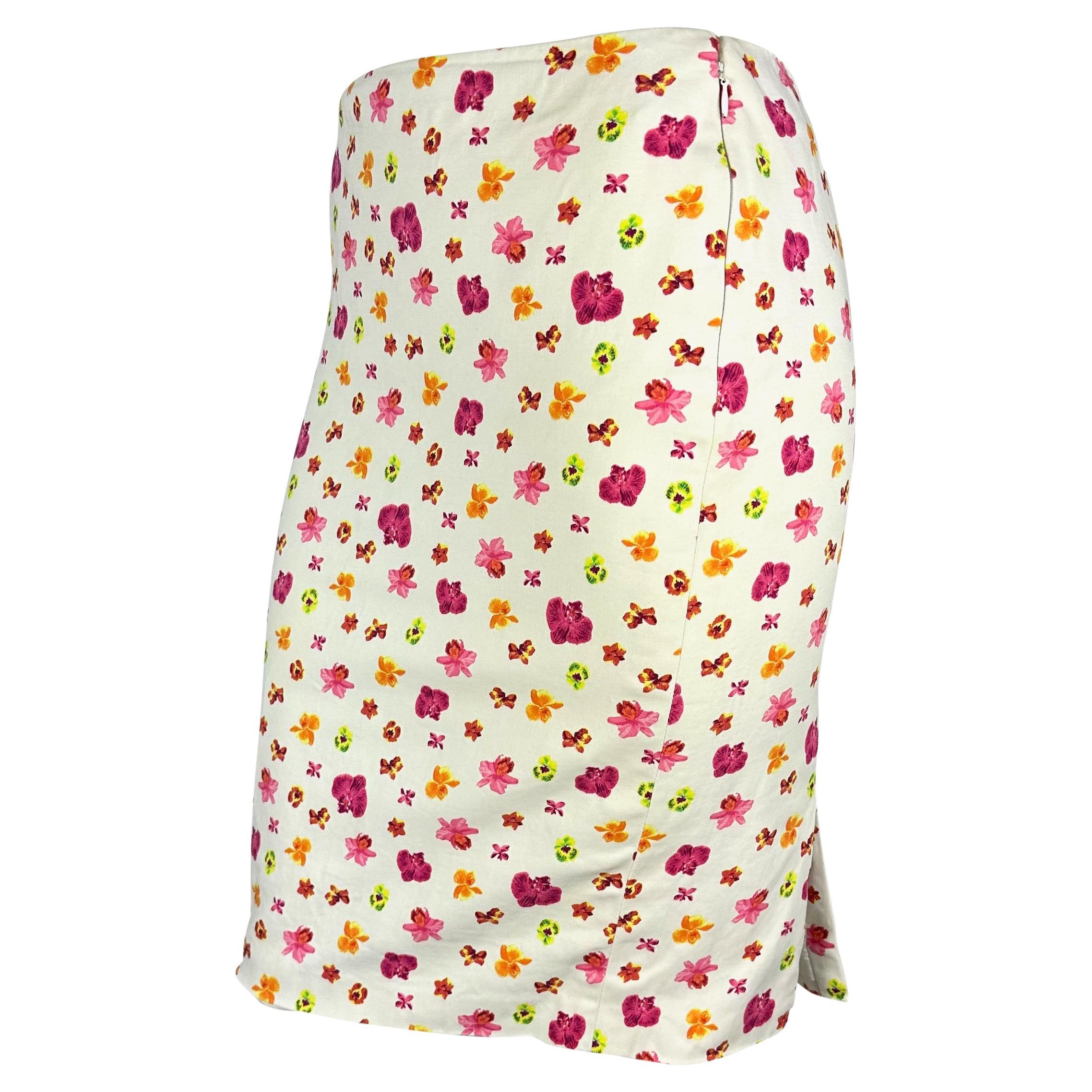 TheRealList presents: a bright floral Versace skirt, designed by Donatella Versace. From the Spring/Summer 2004 collection, this form-fitting off-white skirt is covered in vibrant pink, yellow, and orange flowers. A beautiful Y2K piece, this vibrant
