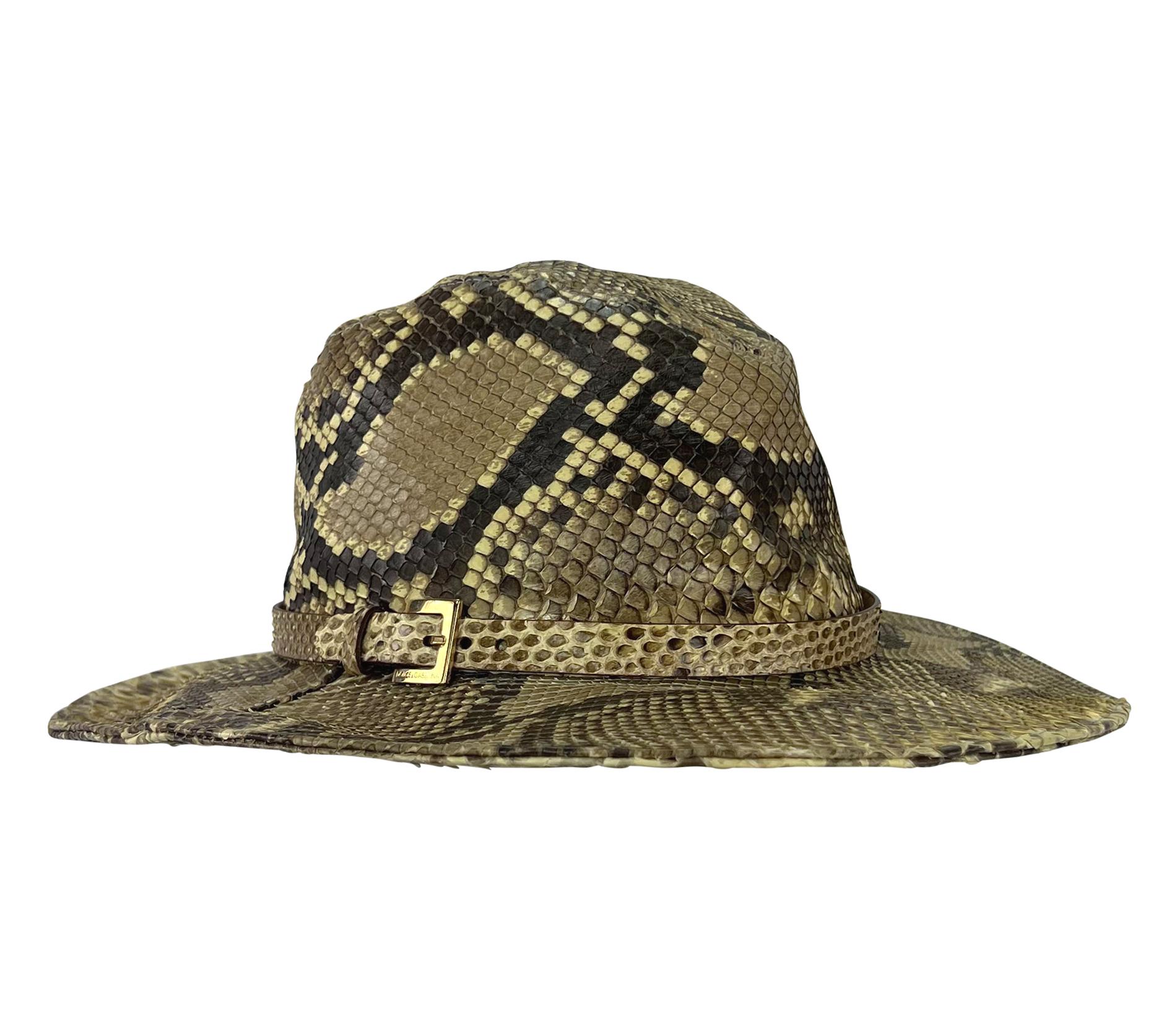 Dalla collezione Primavera/Estate 2005 di Dolce & Gabbana, questo elegante cappello a tesa larga color marrone è realizzato interamente in pelle di pitone. Questo raro cappello ha una fascia intorno alla tesa, fissata con una piccola fibbia dorata