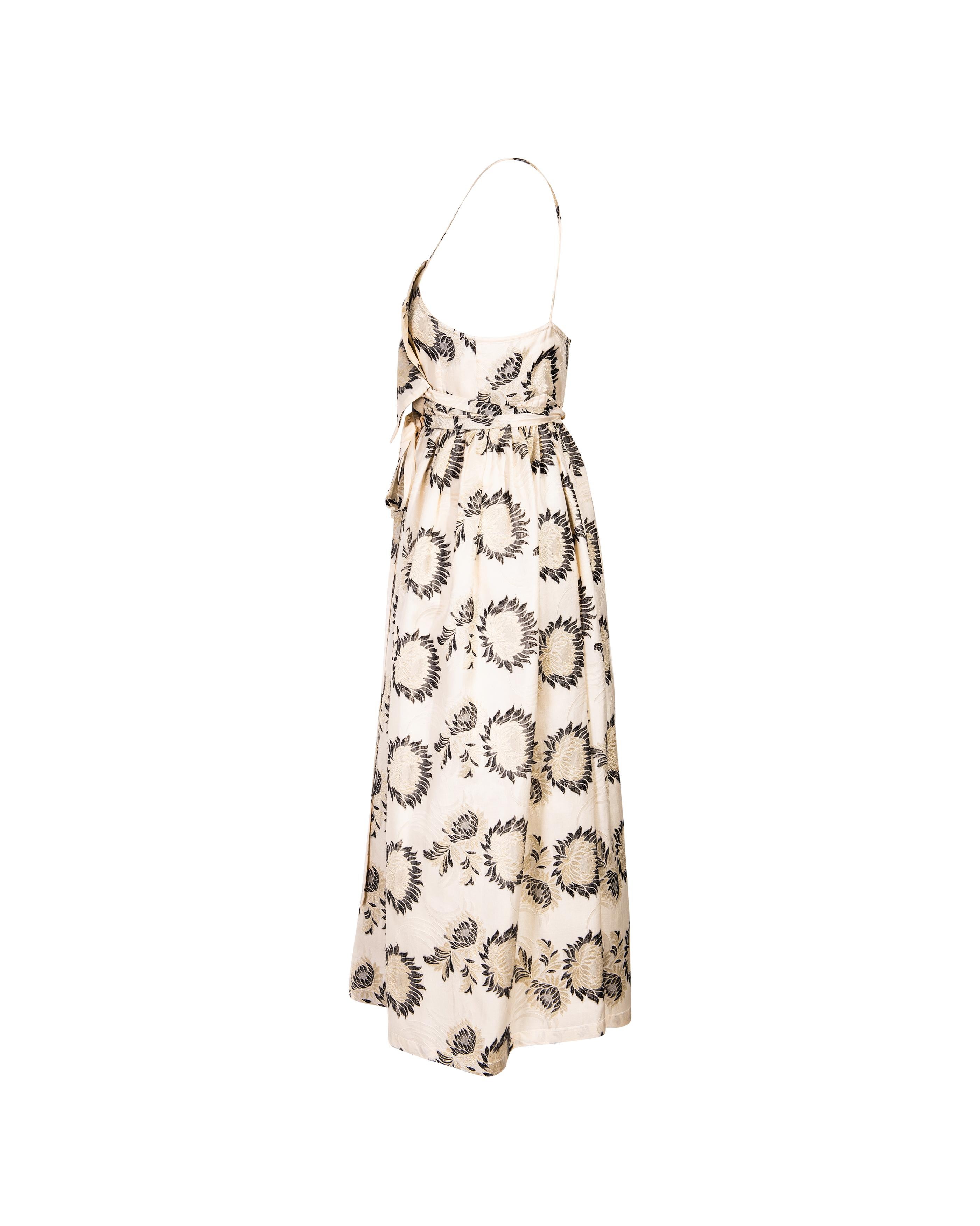 S/S 2005 Dries Van Noten floral print wrap dress. Cream sleeveless midi wrap dress with black and cream floral print throughout. Front ties wrap around waist and create fitted shape, with full flared skirt. 100% Silk. Thin spaghetti straps and