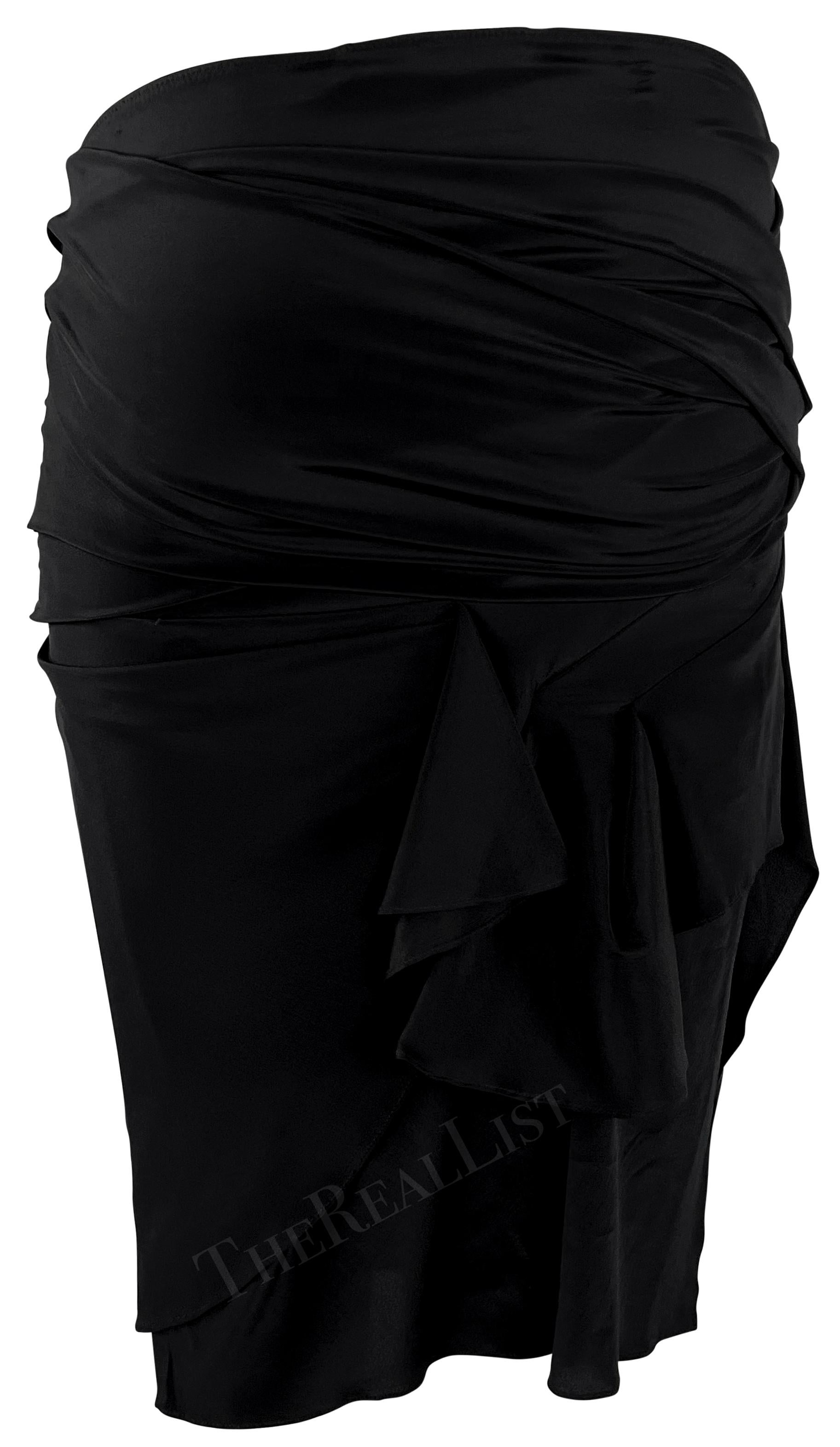 From Gucci’s Spring/Summer 2005 collection, this black stretch skirt is crafted with a sculptural bandage-style wrap construction. Designed to hug the body, it features asymmetric ruching and draped detail with a twisted knot at the front.