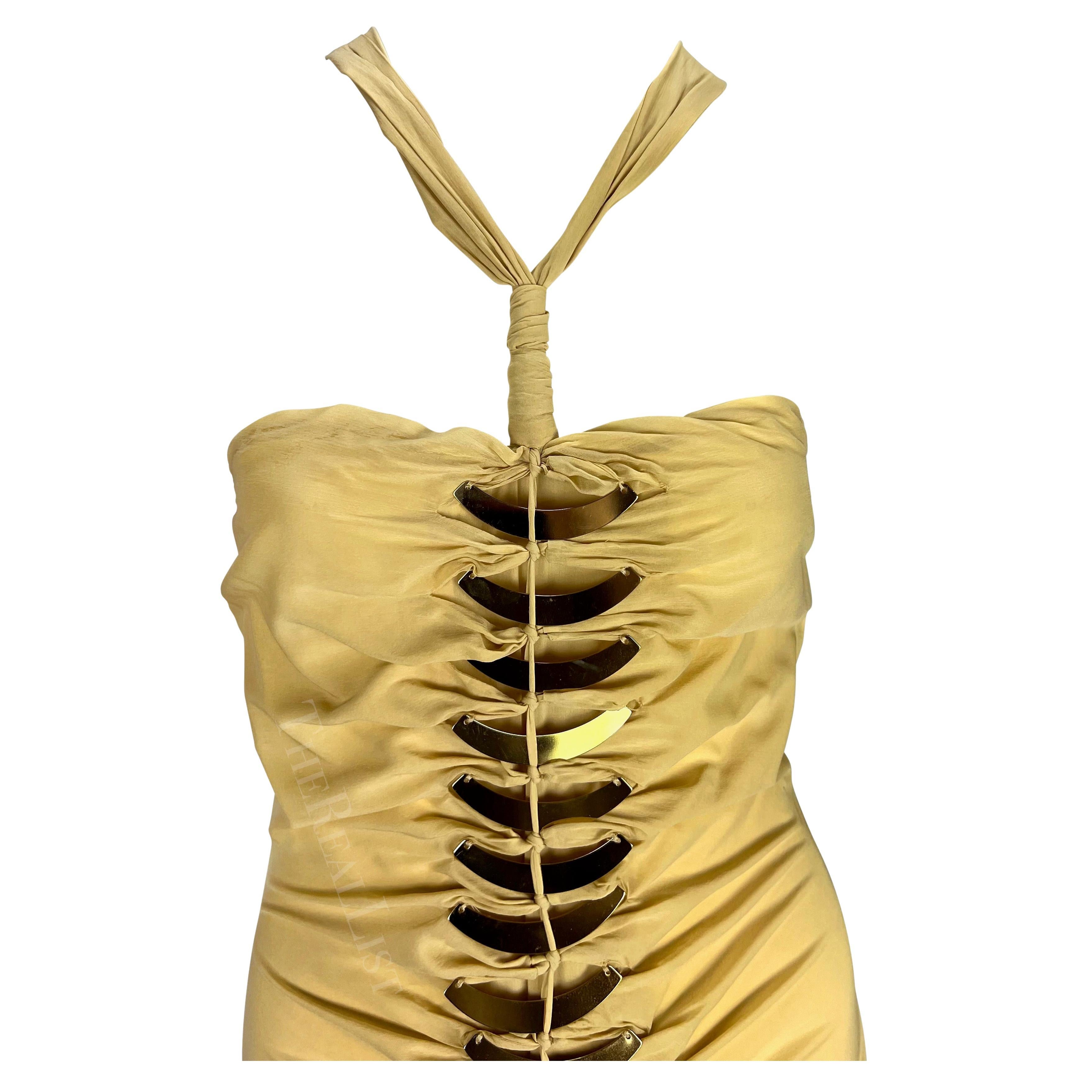 Wir präsentieren ein fabelhaftes Gucci Minikleid mit goldfarbenen Metallakzenten, entworfen von Alessandra Facchinetti. Dieses Kleid aus der Frühjahr/Sommer-Kollektion 2005 zeichnet sich durch goldfarbene Metallakzente aus, die vorne und hinten am