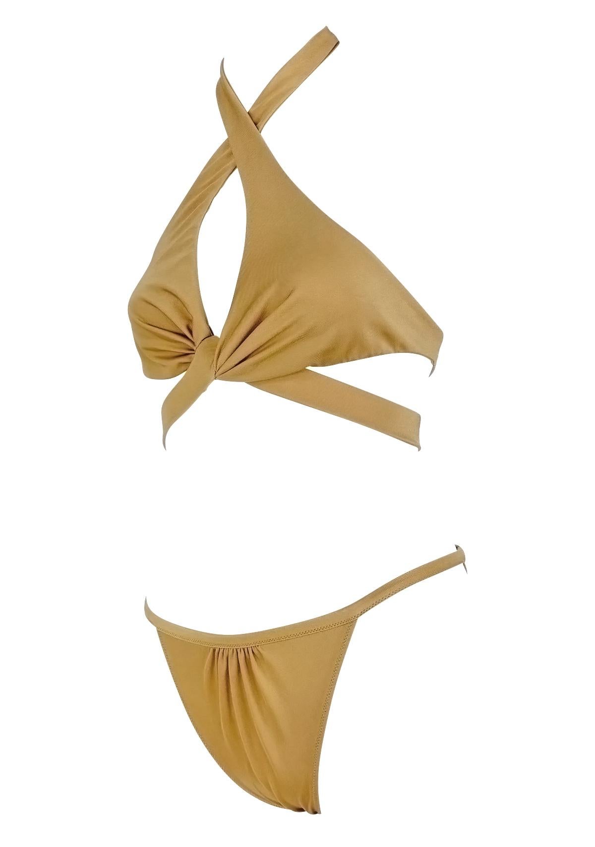 This light tan bikini from Gucci's Spring/Summer 2005 collection by Alessandra Facchinetti features a halter top with a crisscross wrap detail at the bust and coordinating low-rise bottoms. The design is finished with wide back straps and a clasp
