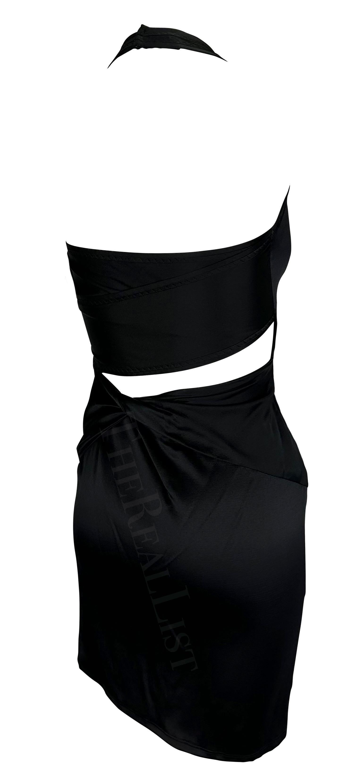 Presenta un miniabito a collo alto in raso nero di Gucci, disegnato da Alessandra Facchinetti. Dalla collezione primavera/estate 2005, questo abito presenta un'arricciatura sul davanti, dei ritagli sulla schiena e una cerniera nascosta sul