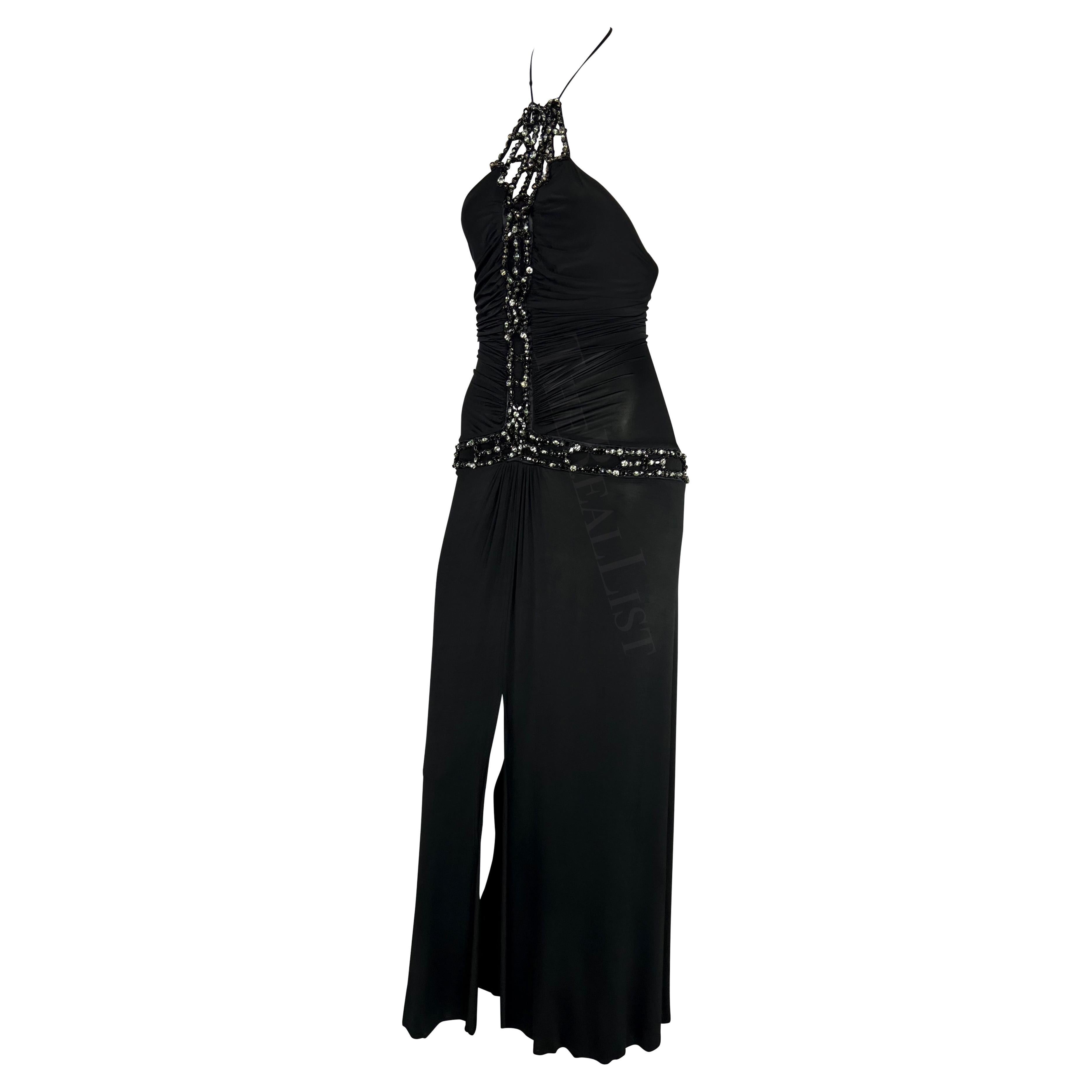 Presenting a fabulous black Roberto Cavalli slinky gown. From the Spring/Summer 2005 collection, this full-length dress features a halter neck and rhinestone embellishments that go down the front of the dress and around the hips. This form-fitting