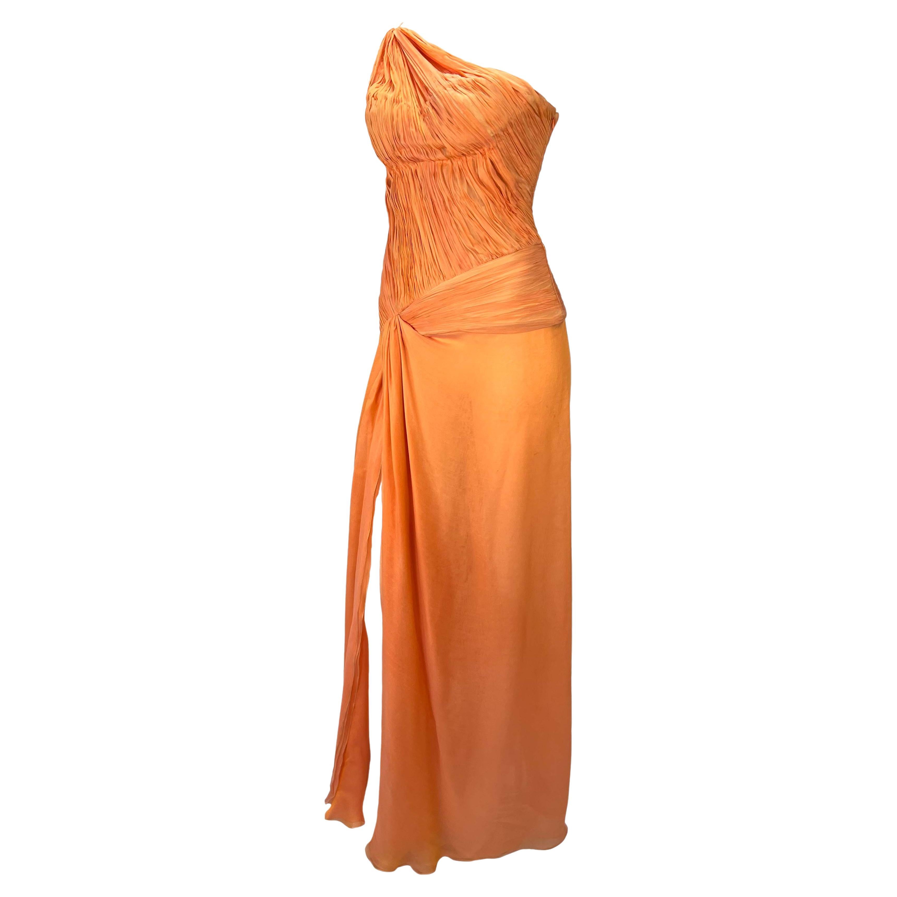 Presenting a stunning bright orange ruched Roberto Cavalli gown. From the Spring/Summer 2005 collection, this asymmetric gown is constructed entirely of light persimmon silk chiffon. The dress features a single shoulder strap, ruched body, flowing