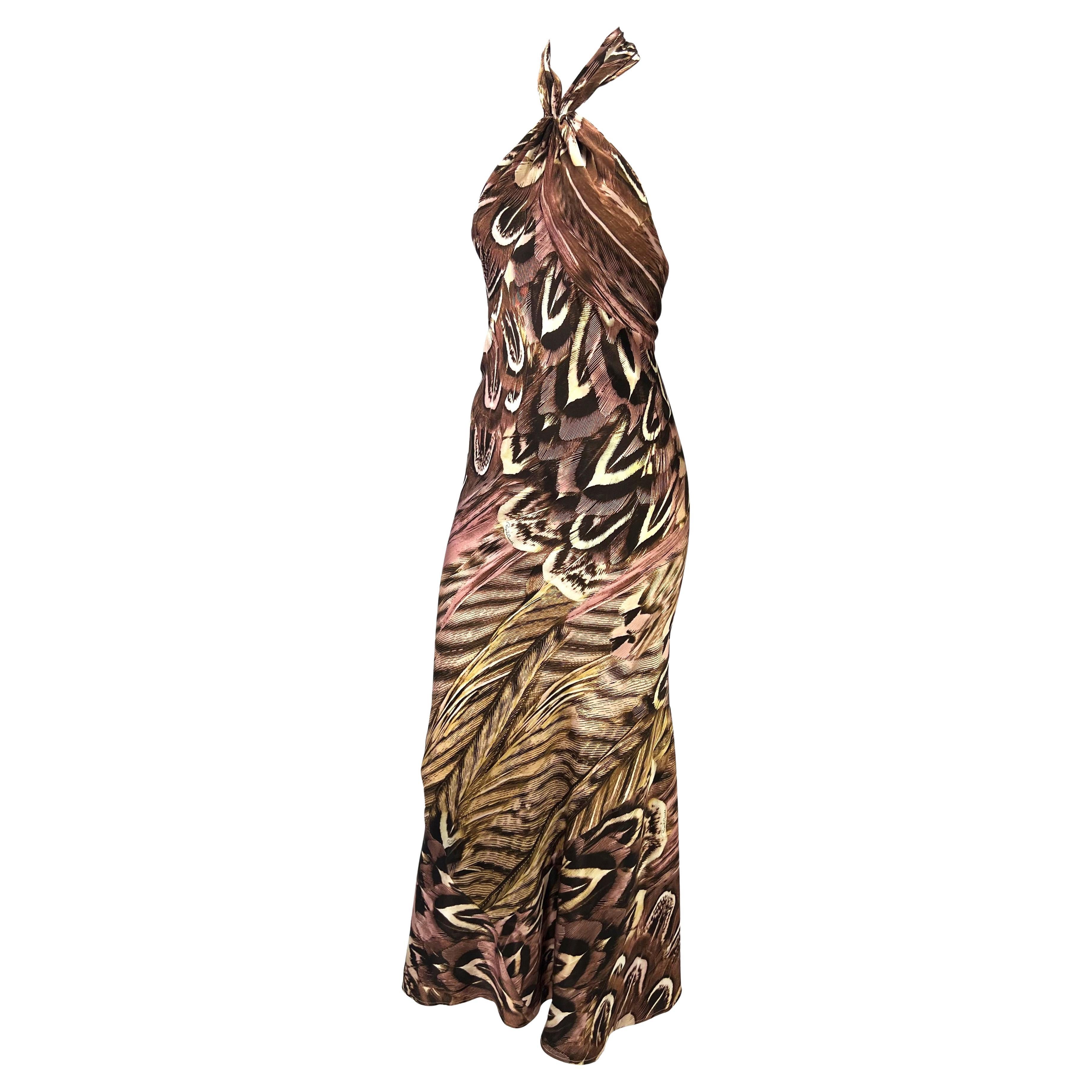 Presenting a beautiful feather print Roberto Cavalli gown. From the Spring/Summer 2005 collection, this halterneck dress is constructed entirely of a feather print silk that features a variety of pink and brown hues. The dress ties at the nape and