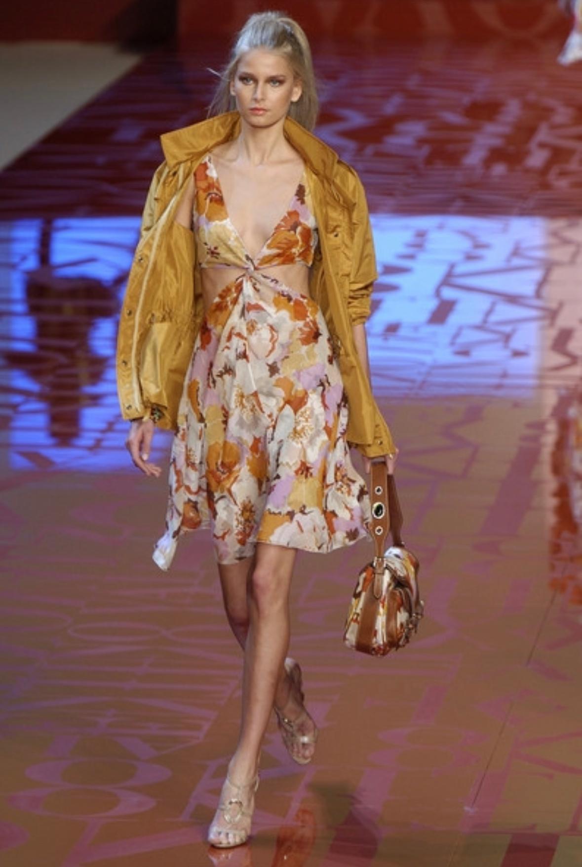 Presenting a fabulous orange floral Valentino dress. From the Spring/Summer 2005 collection, this dress debuted on the season's runway as part of Look 9, modeled by Hana Soukupova. This chic dress features a deep v-neckline, knots under the bust and