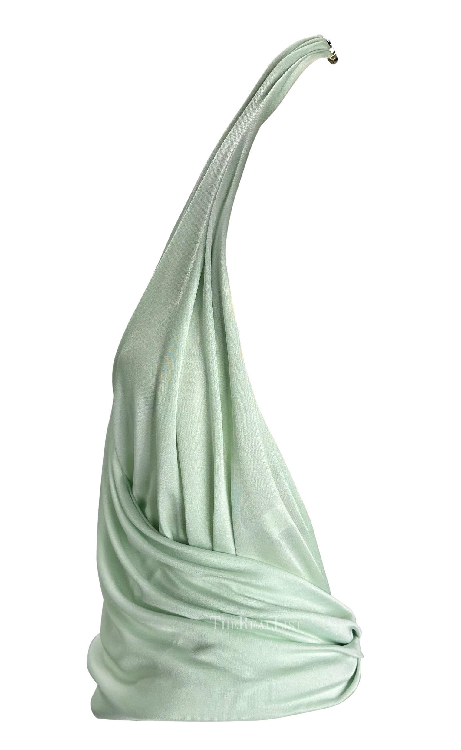Te presentamos un cuello halter Versace color menta diseñado por Donatella Versace. De la colección Primavera/Verano 2005, este top envolvente de cuello halter se completa con un gran medallón de Medusa Versace entrelazado en la parte inferior de la