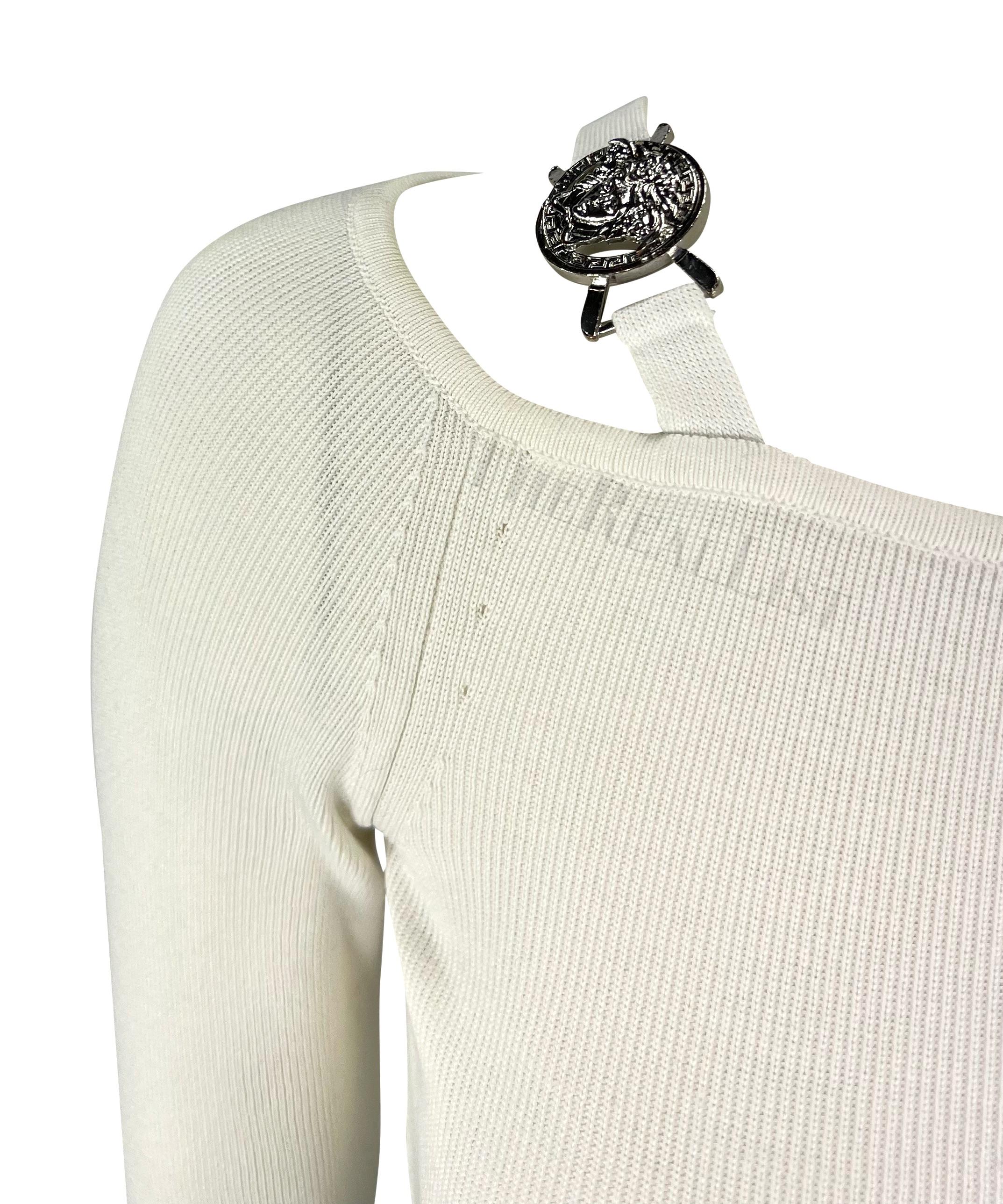 Presenting a chic white Versace long-sleeve knit top, designed by Donatella Versace. From the Spring/Summer 2005, this form-fitting ribbed knit top features a wide neckline that is accented with silver-tone Versace Medusa reliefs on either side of