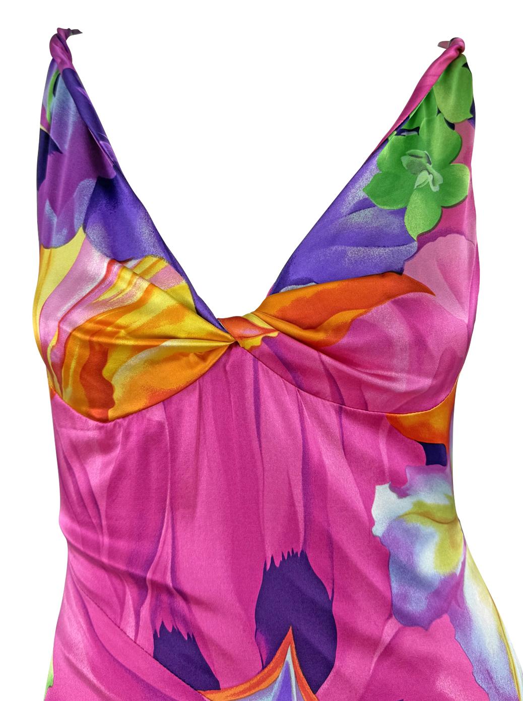 From Versace’s Spring/Summer 2005 collection, this satin bodycon dress features a vivid neon floral print in shades of magenta, yellow, purple, and green. Designed in a stretch satin, it hugs the silhouette with a gathered bust and deep V neckline