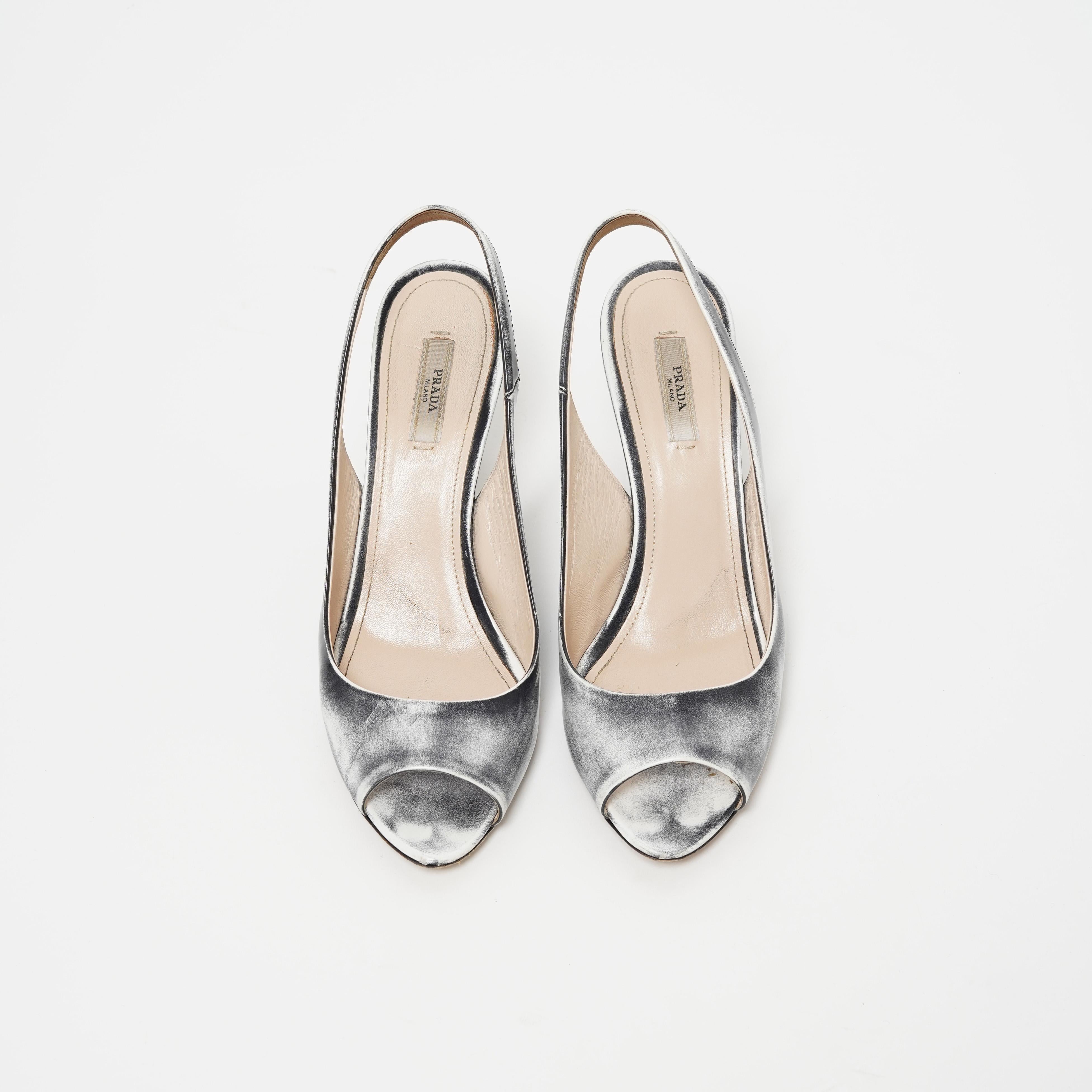 Presenting the Prada Spring/Summer 2010 distressed leather effect slingback wedge sandals—an iconic statement piece that merges futuristic innovation with timeless elegance. These sandals encapsulate Prada’s avant-garde aesthetic, balancing modern