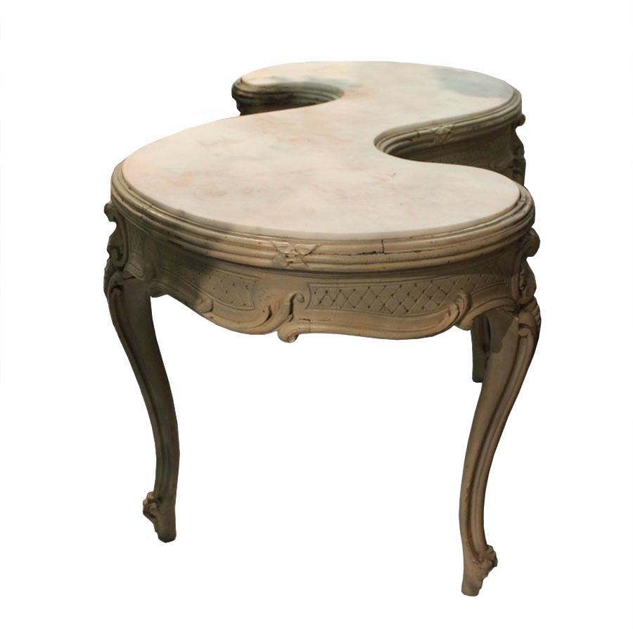 This antique 19th century French table features a beautiful 's' shaped marble top, and could be used a dressing table or wonderful display table. This piece has four elegantly carved legs, and has decorative detailing all around the sides.
 