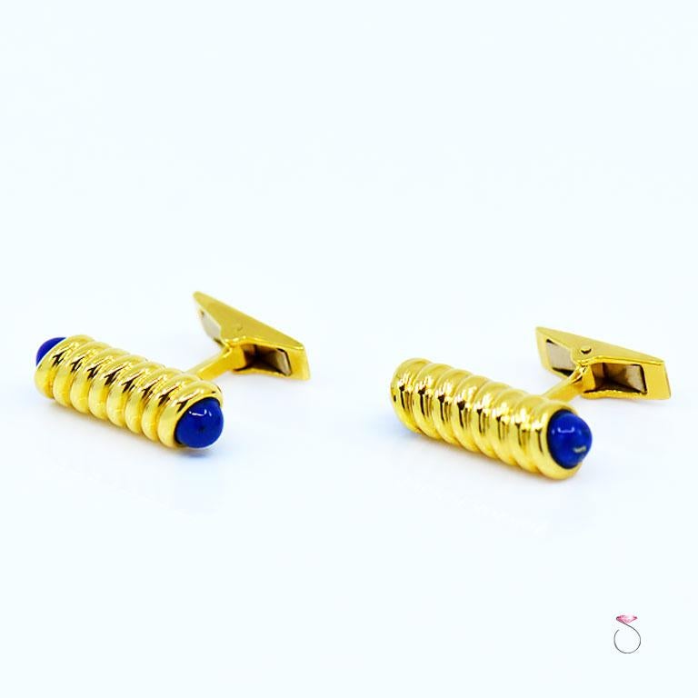 Very elegant authentic S. T. Dupont pair of Lapis Lazuli cufflinks in 18K yellow gold. These cufflinks are beautifully designed and crafted in 18K with rope design that holds two Lapis Lazuli beads on each end. The back of the cufflinks folds on