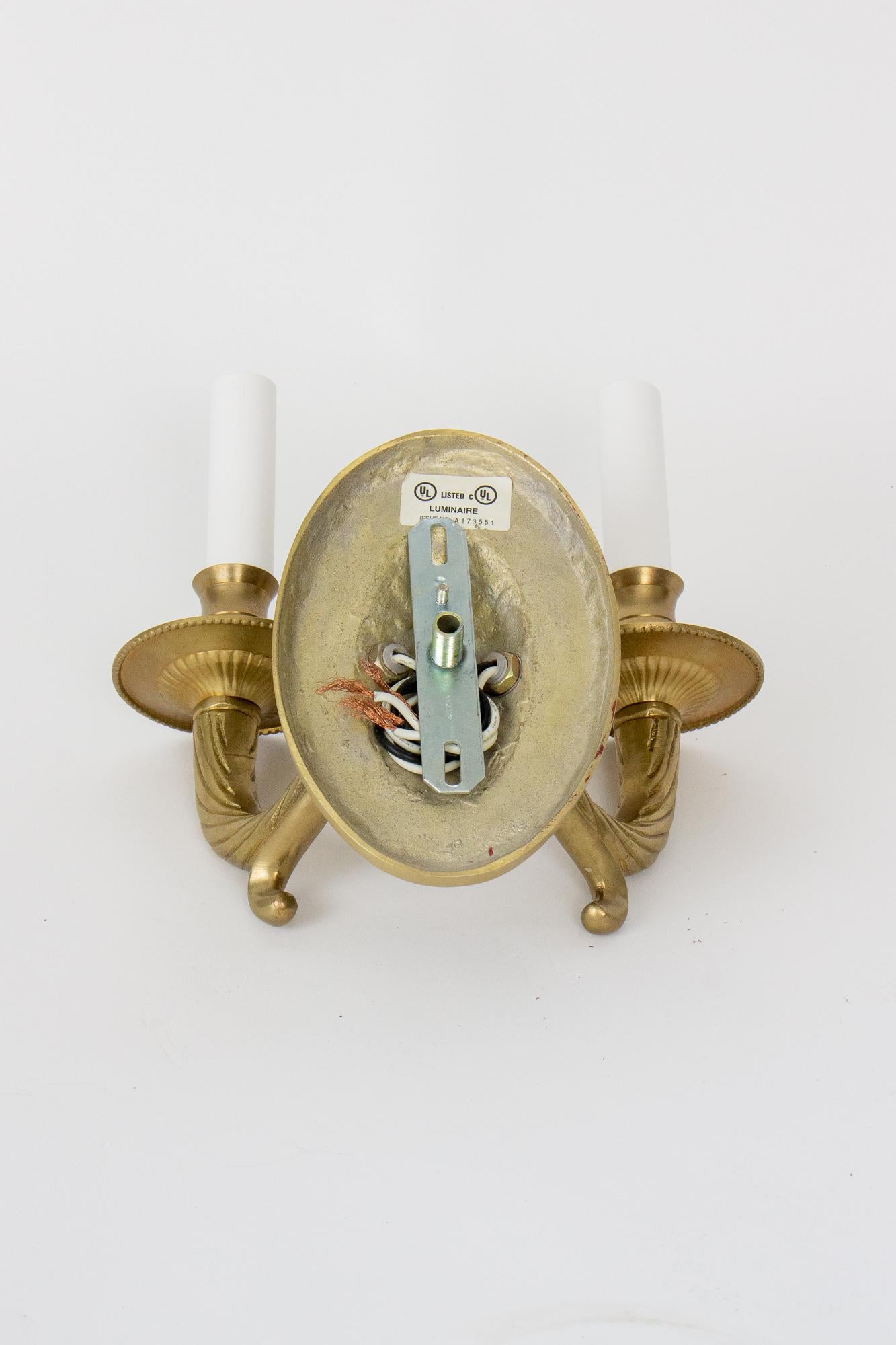 Solid cast brass sconces with an oval detailed backplate. Two arms. Ready to install. UL listed. 40 watt max in each socket. 
Dimensions: 
8.5” Width x 4.5” Depth x 9” Height 
C. 1980.