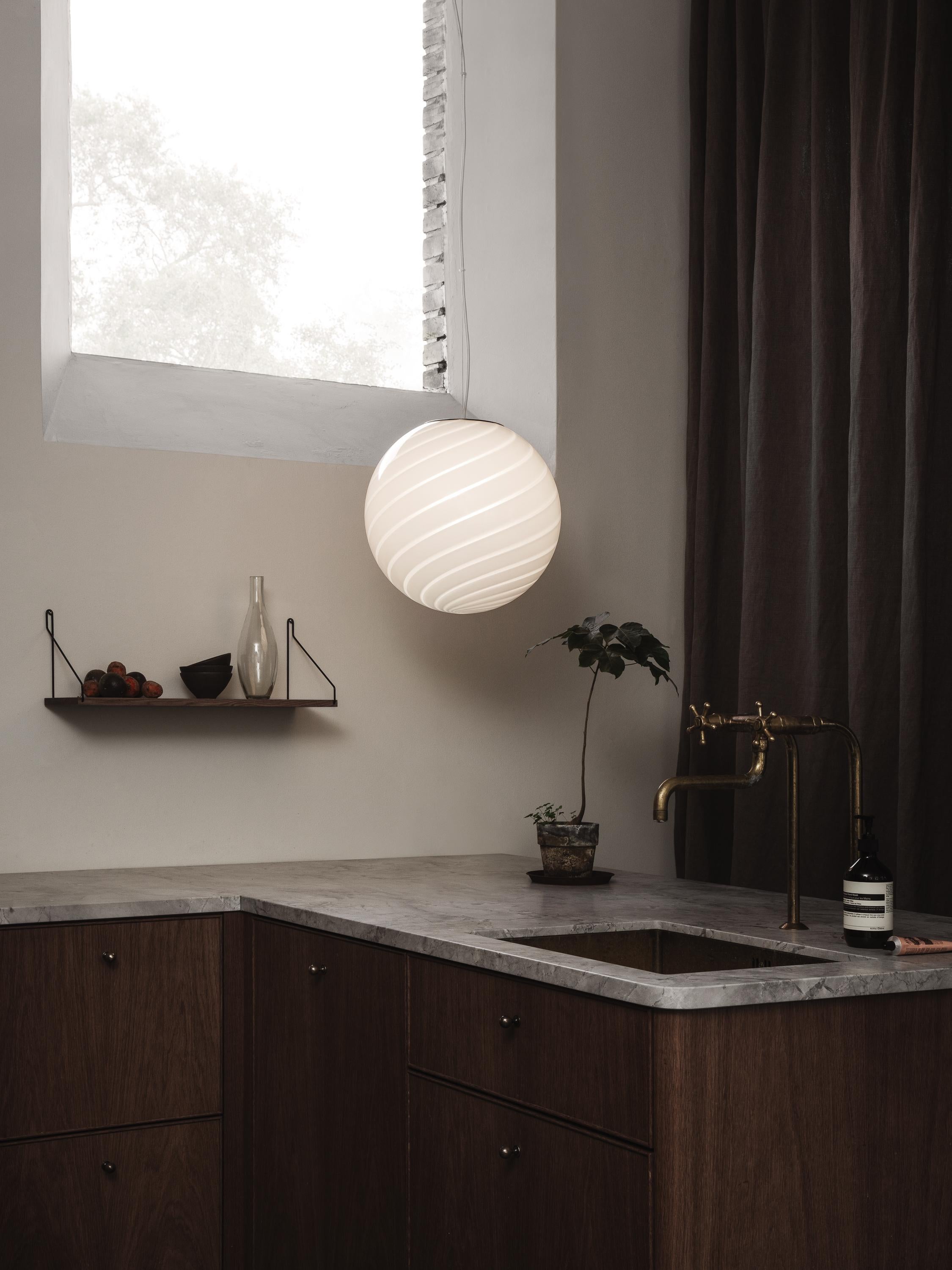 Sphere-shaped pendant ceiling lamp crafted from mouth-blown opaline glass. The design features a swirl pattern obtained using an original 1970s mould, specifically picked to give the lamp a clean expression. The piece includes a hand-casted fitting