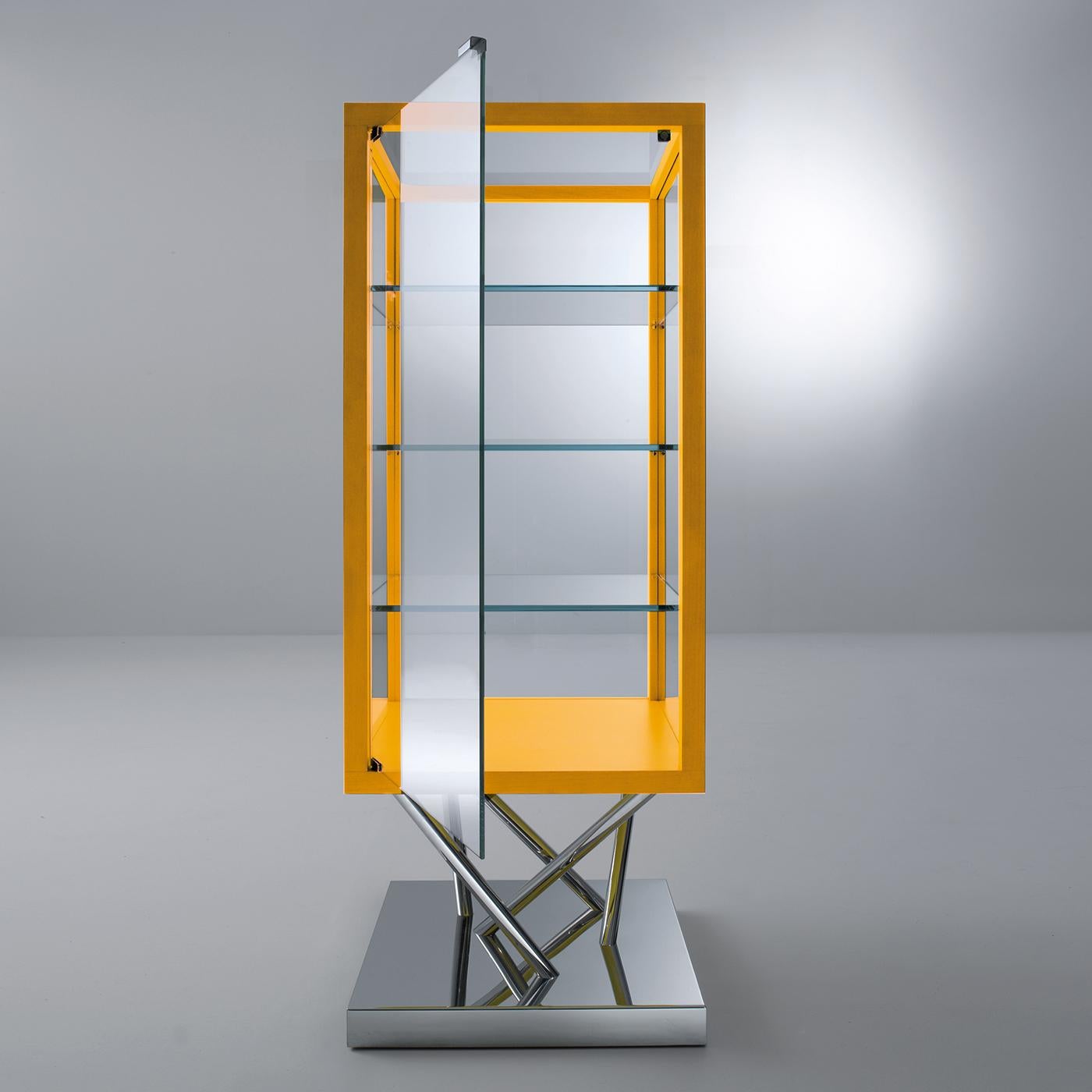 This cabinet features a polished steel base and is trimmed in yellow aniline-stained maple. It features one hinged door. Its side panels, back and top are in ultra-light glass. On request, it is also available in satin glass. SA 02 is a sculptural
