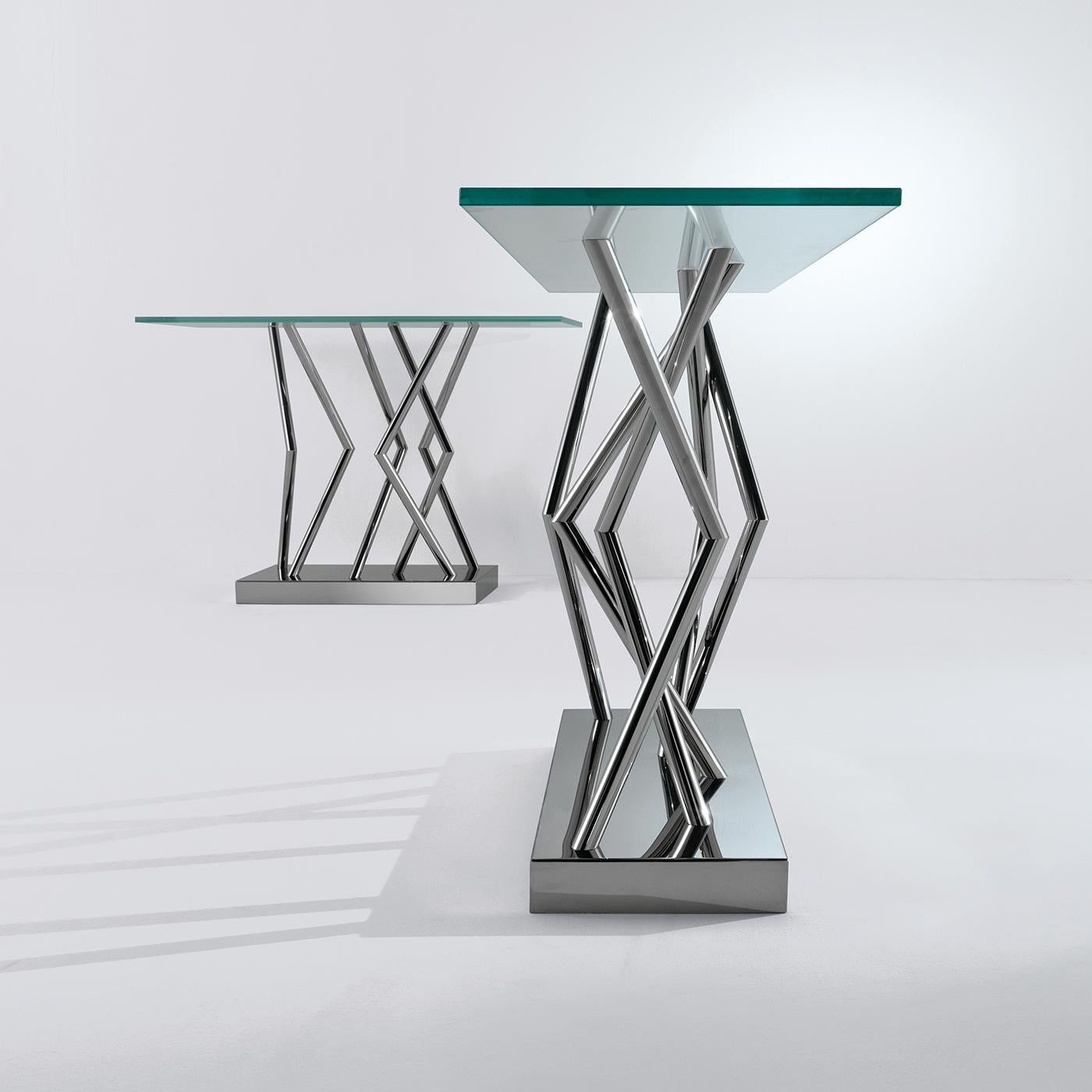 This unique console table with a transparent, rectangular glass top rests on various rods in polished steel that are bent in various directions for a geometrical effect, and the rods all rest on a stainless-steel base. A table that will add a touch