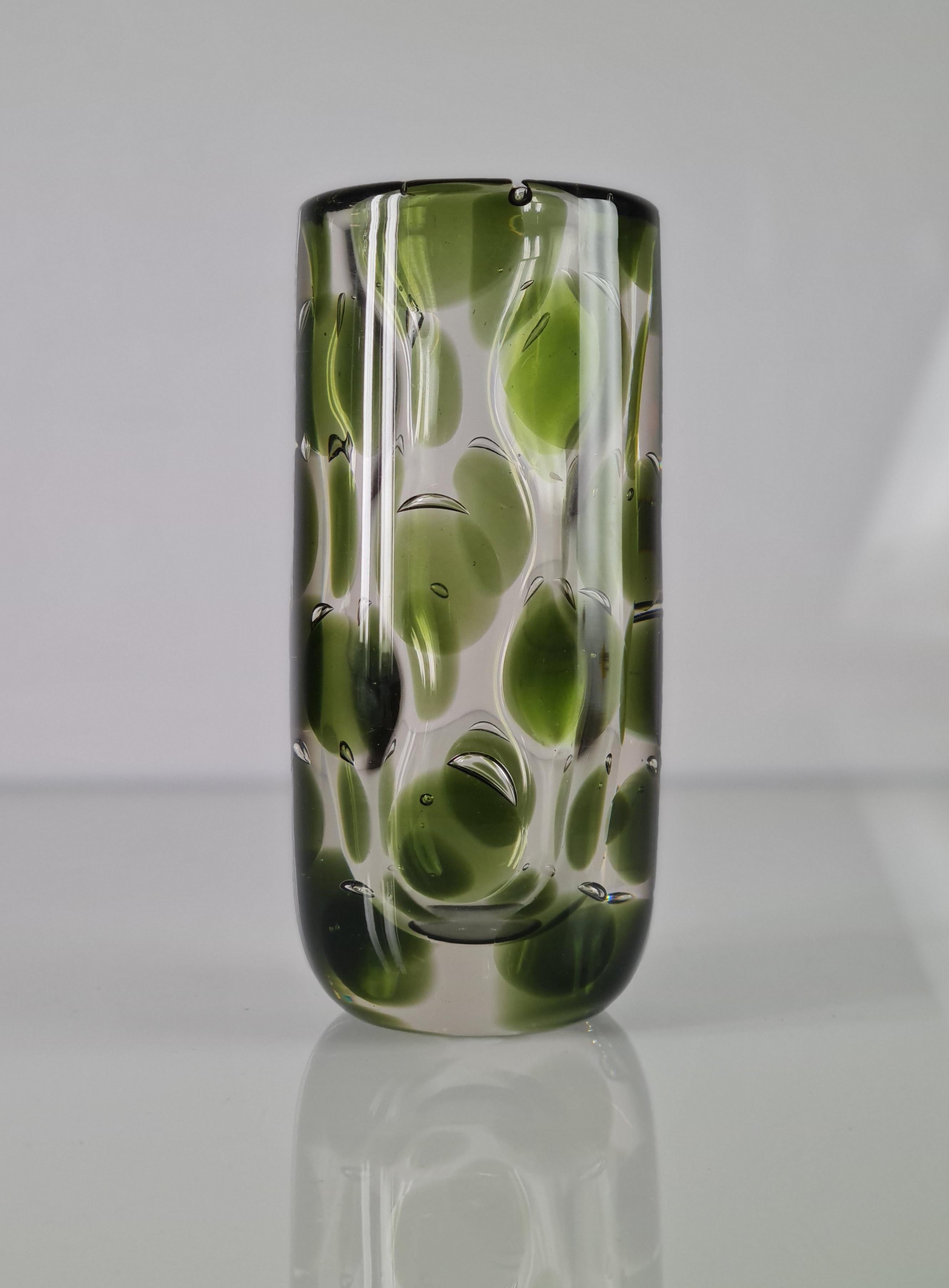 An eye-catching transparent art glass vase with green spots through out the object, imitating a panther. Designed by one of the leading names in the glass scene of her time in Finland, Saara Hopea. Saara always had a unique approach to her many
