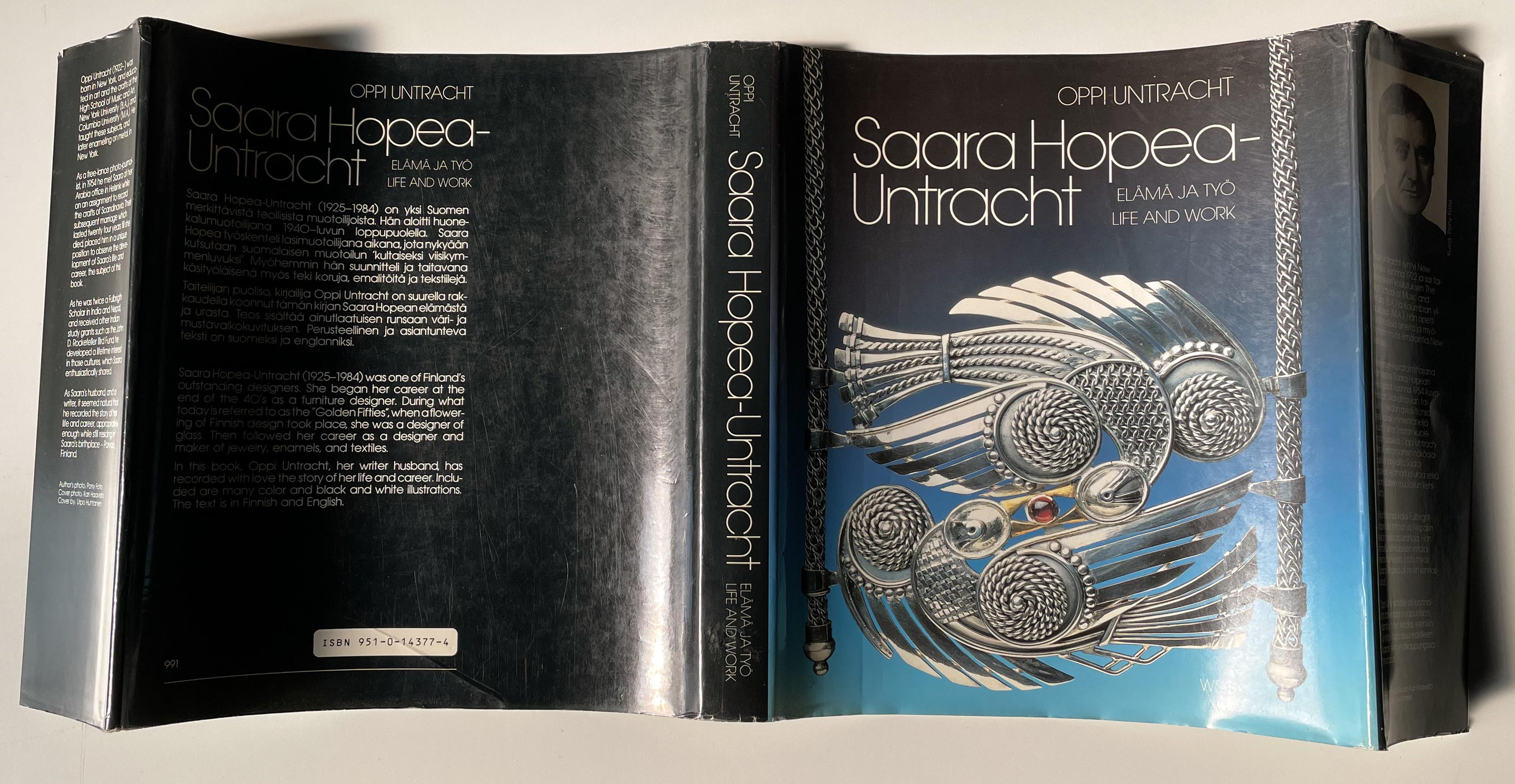 Monograph on renowned and prolific mid-century Finnish designer Saara Hopea-Untracht, written by her husband, the American metalsmith, educator, and writer Oppi Untracht. Published in 1988 by Werner Soderstrom Osakeyhtio. Small 4to (9