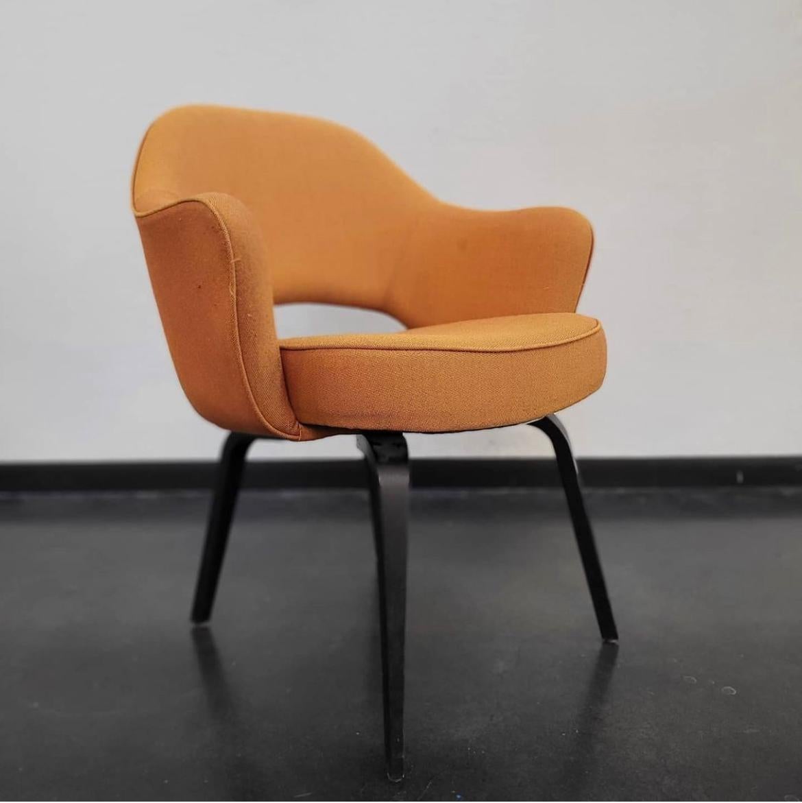 A pair of orange upholstered Eero Saarinen for Knoll executive chairs.